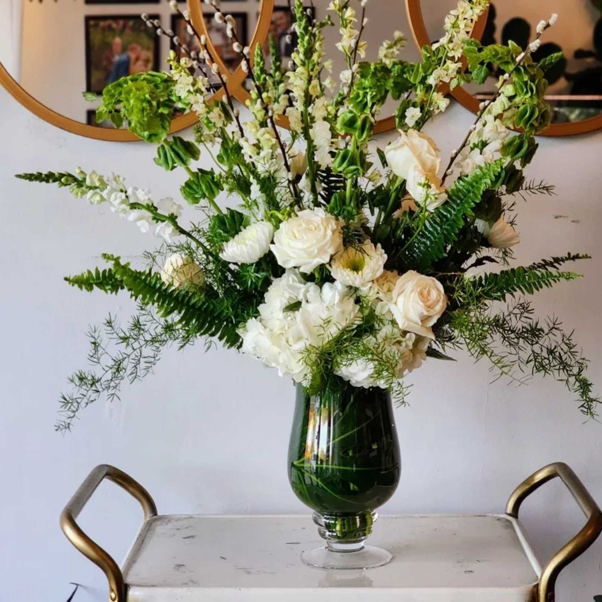 White floral arrangement in a dark glass vase