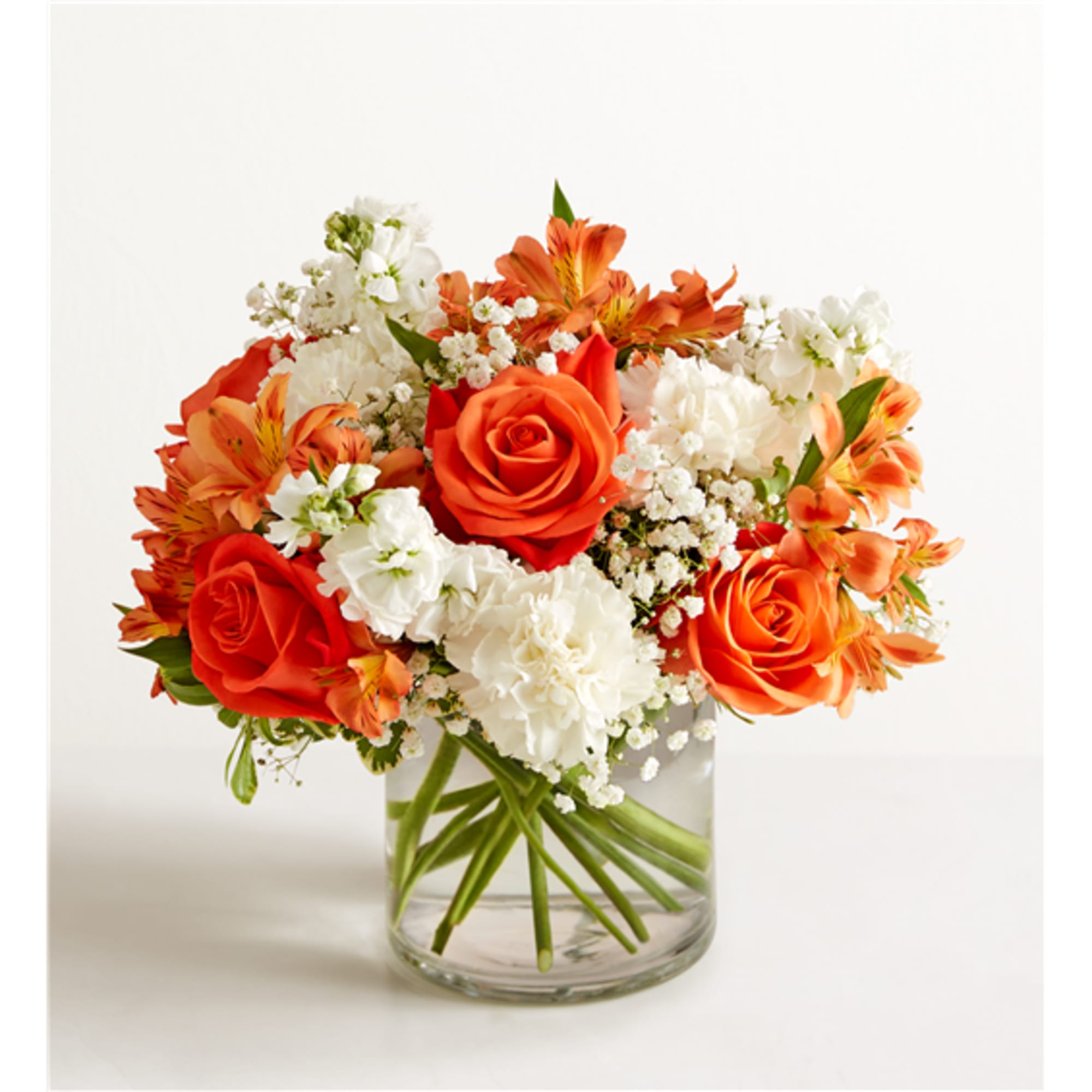 Orange and white flower arrangement in a clear glass vase
