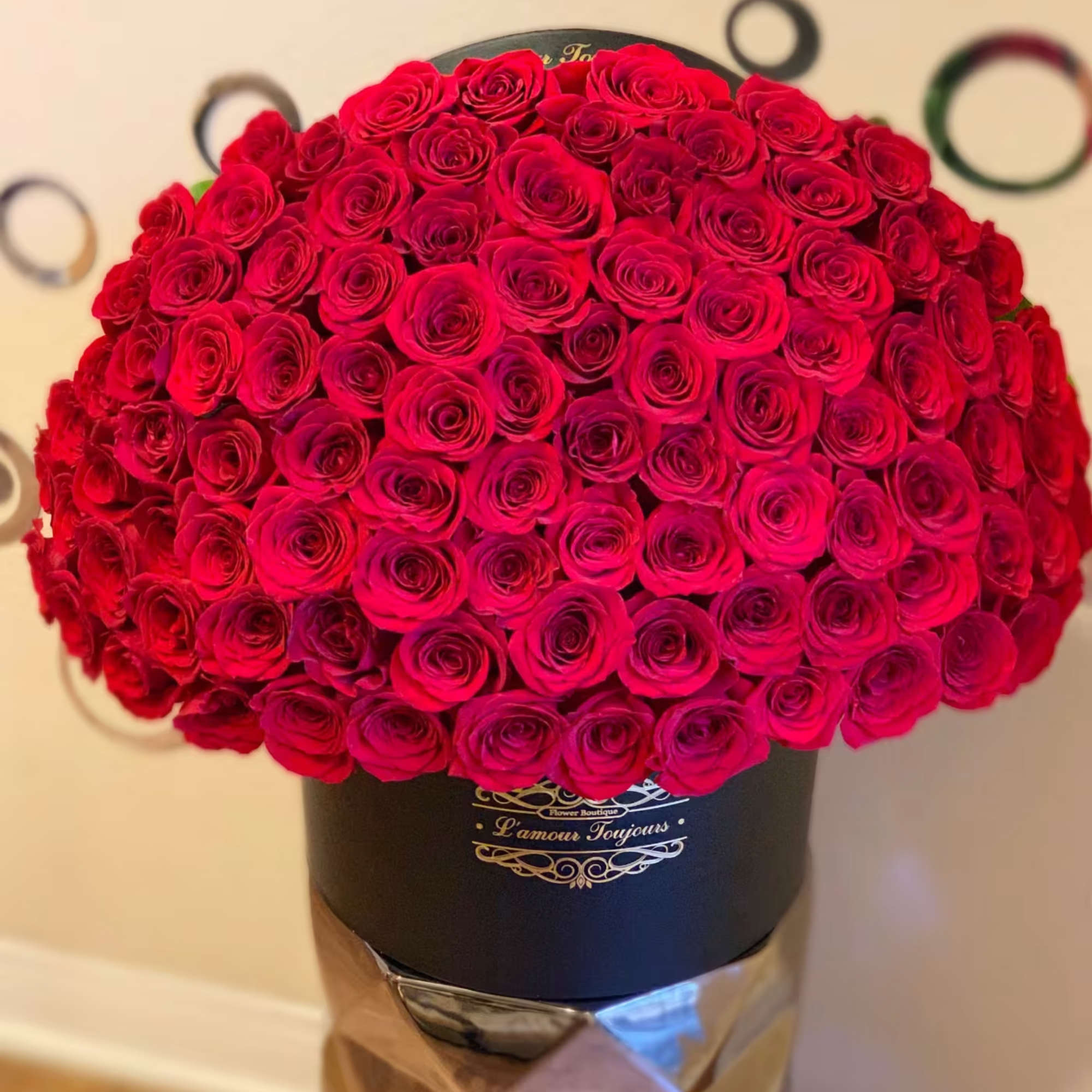 Large bouquet of red roses in a black hat box