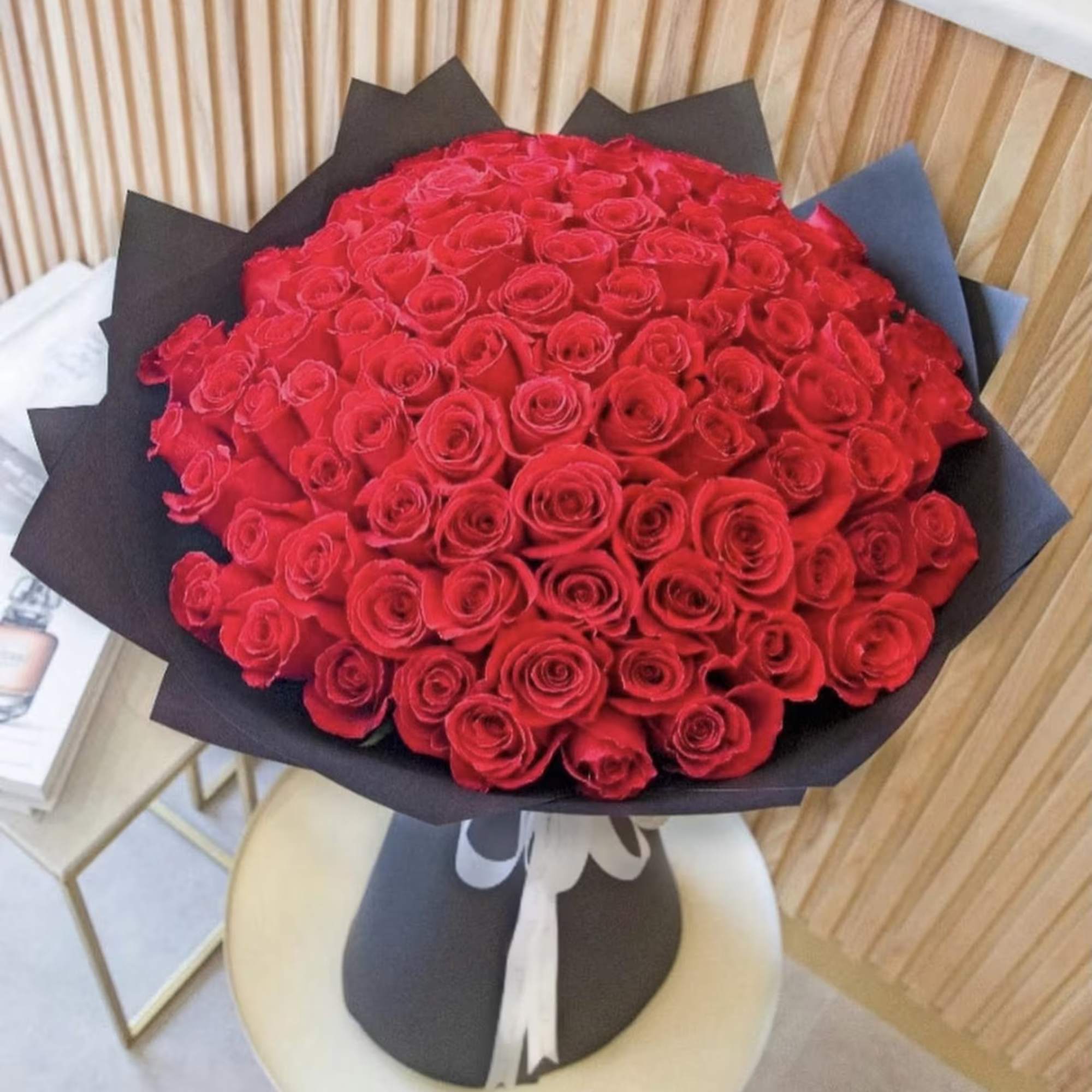 Large bouquet of red roses wrapped in black paper