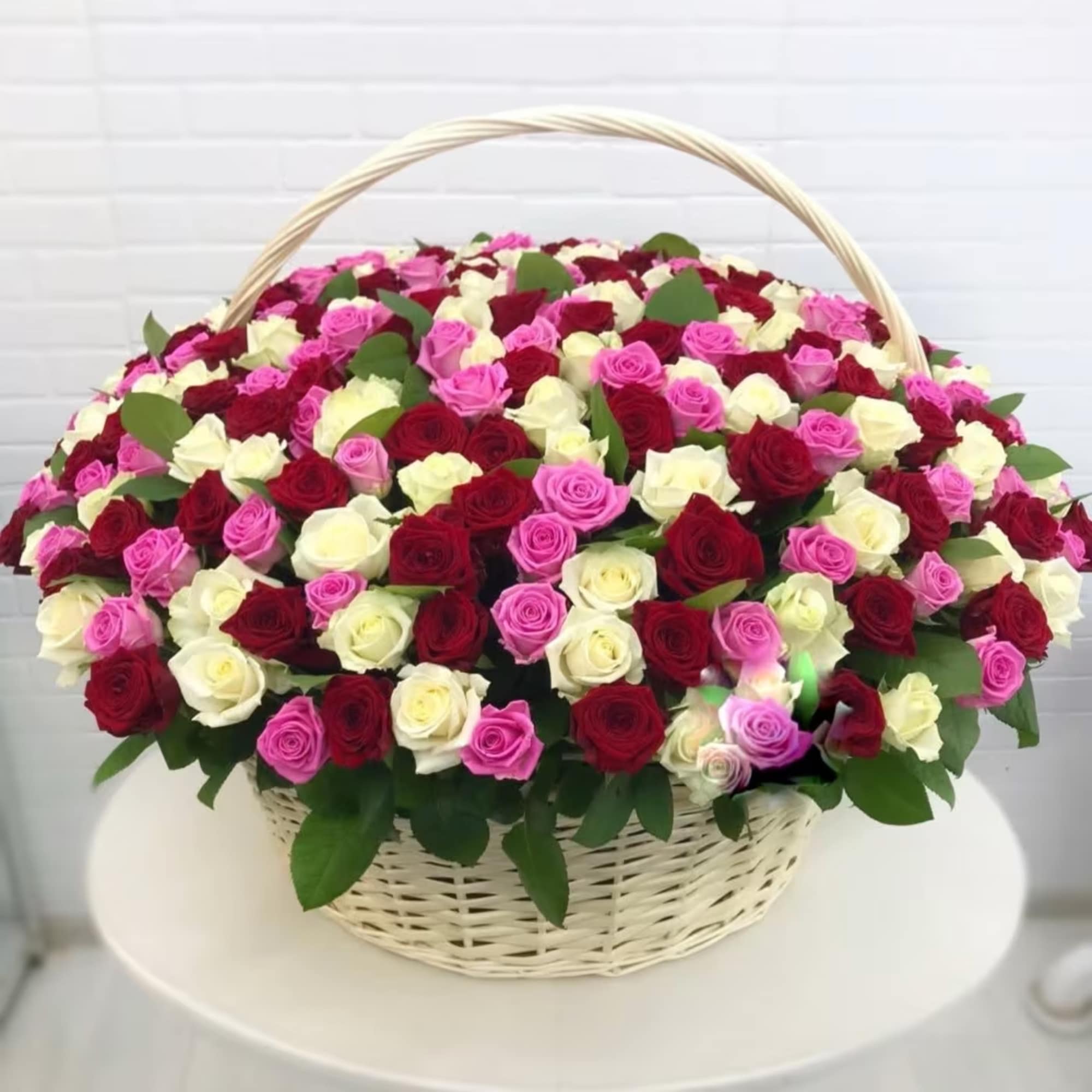 Basket of red, pink, and white roses with a woven handle