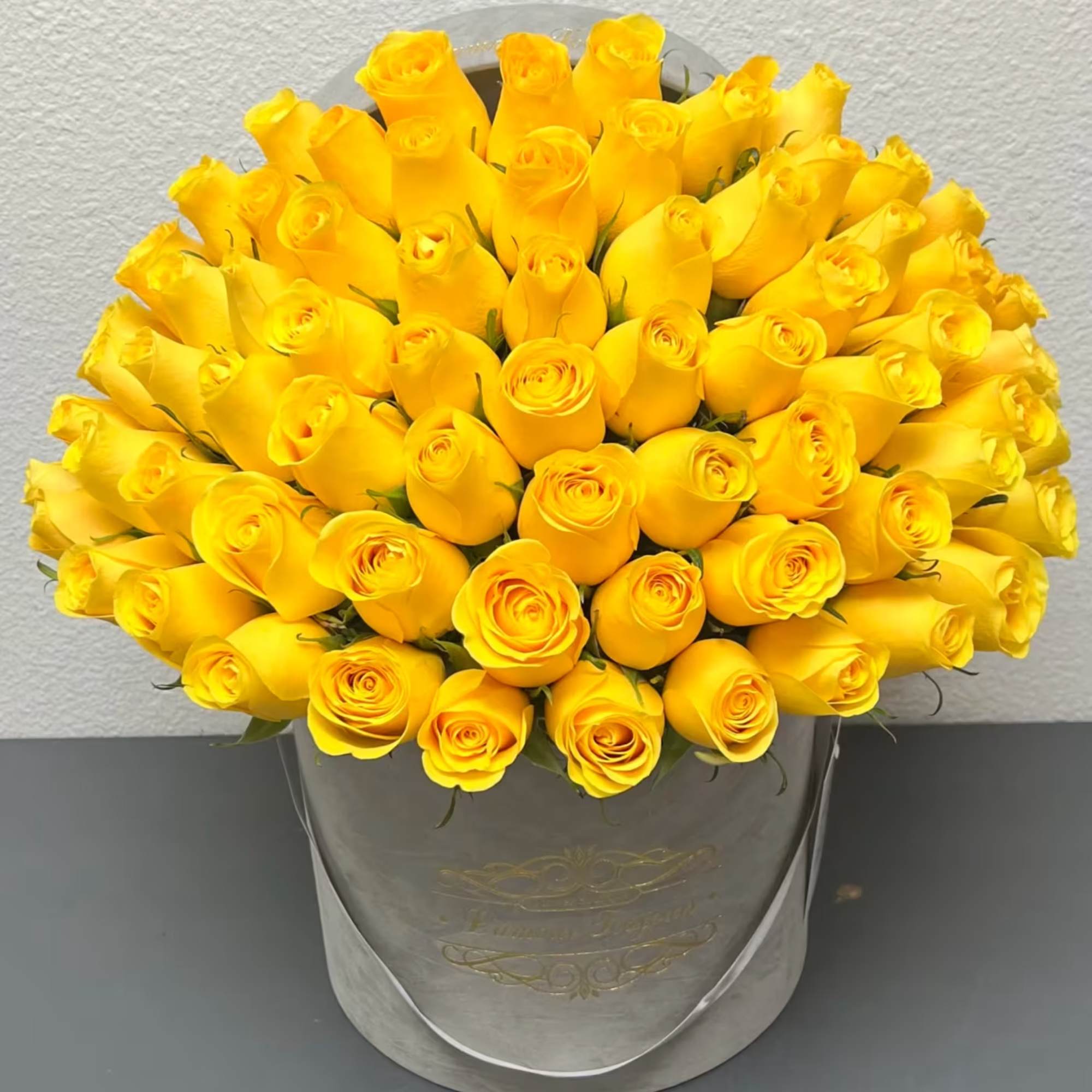 Bouquet of yellow roses in a gray hatbox