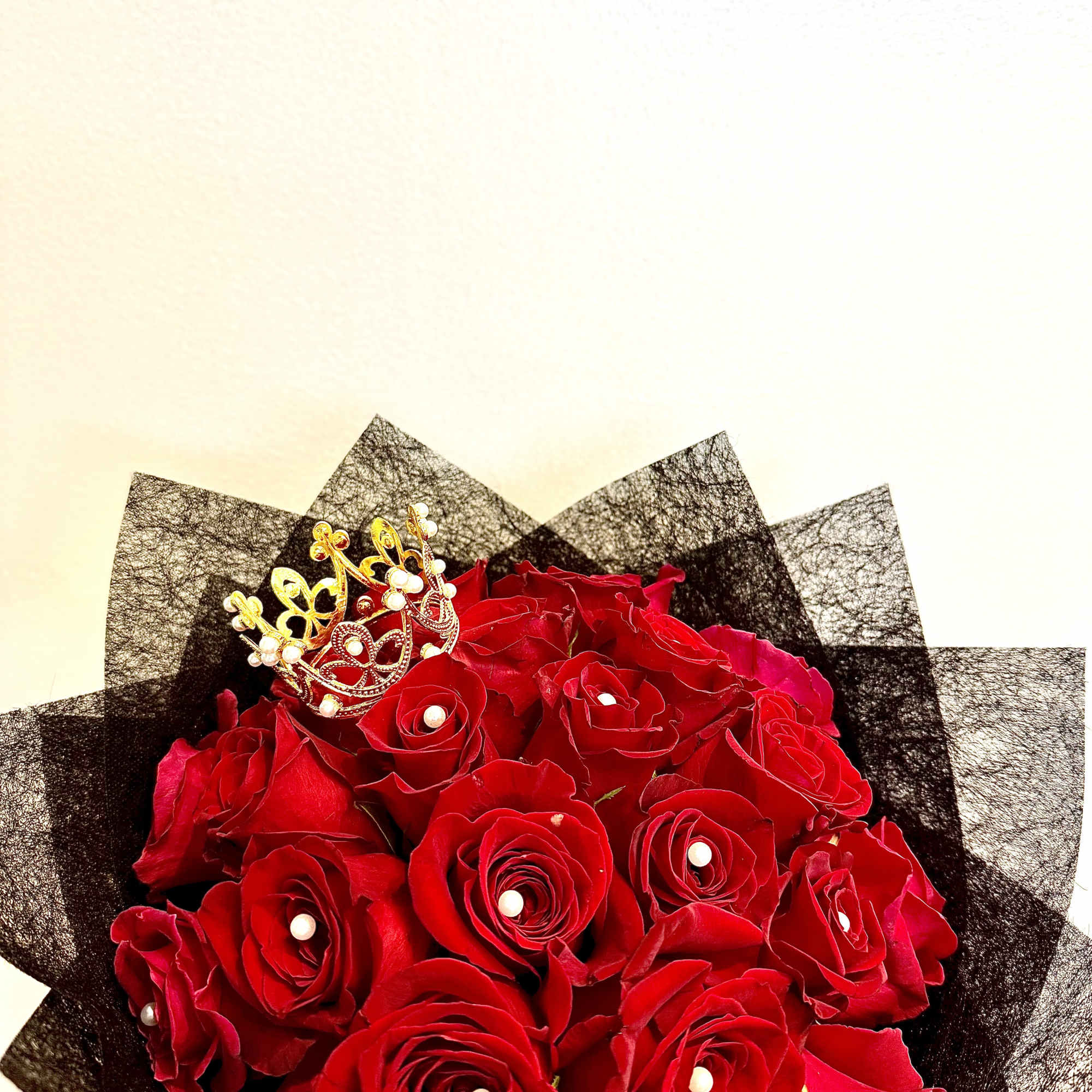 Bouquet of red roses with a small gold crown topper