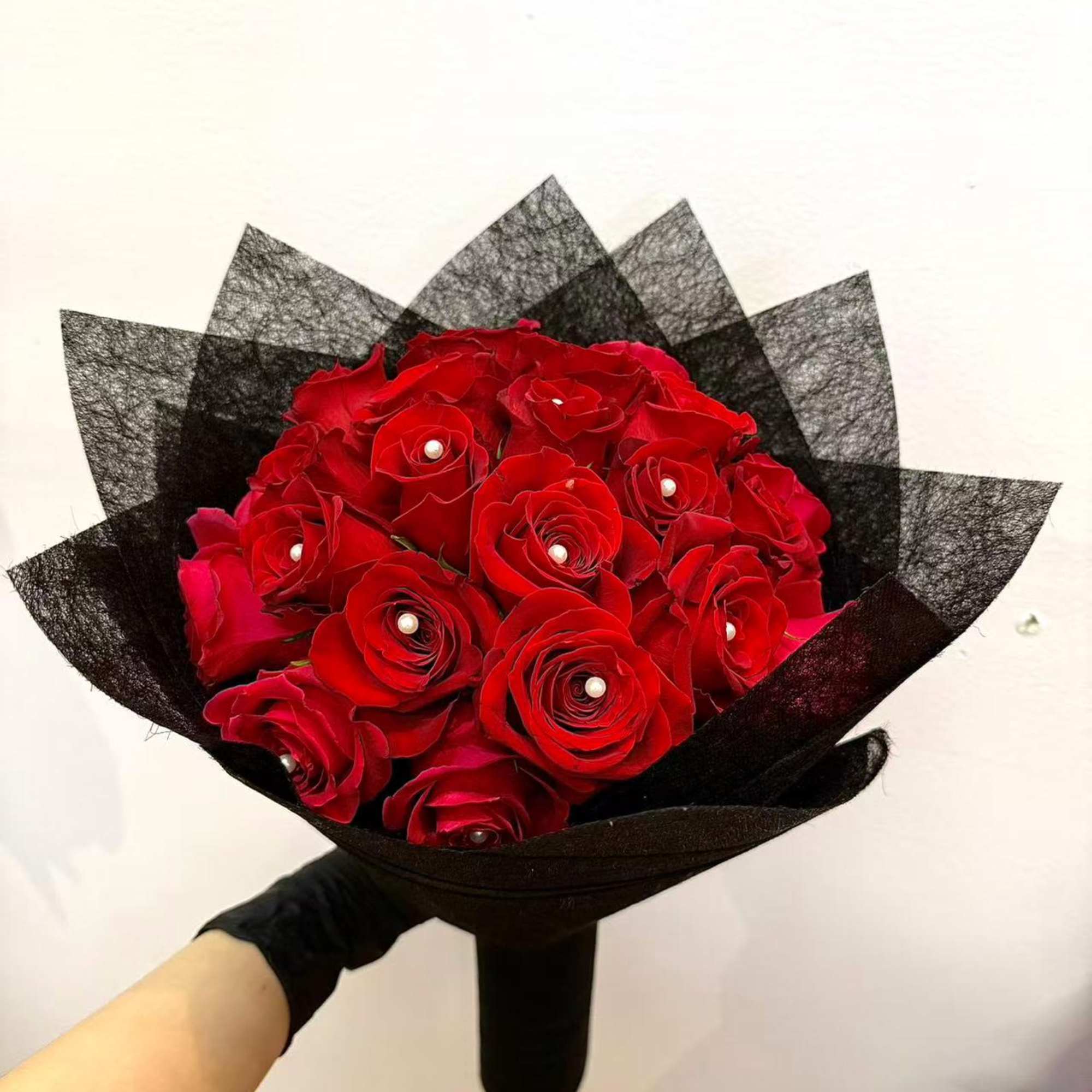 Bouquet of red roses wrapped in black paper
