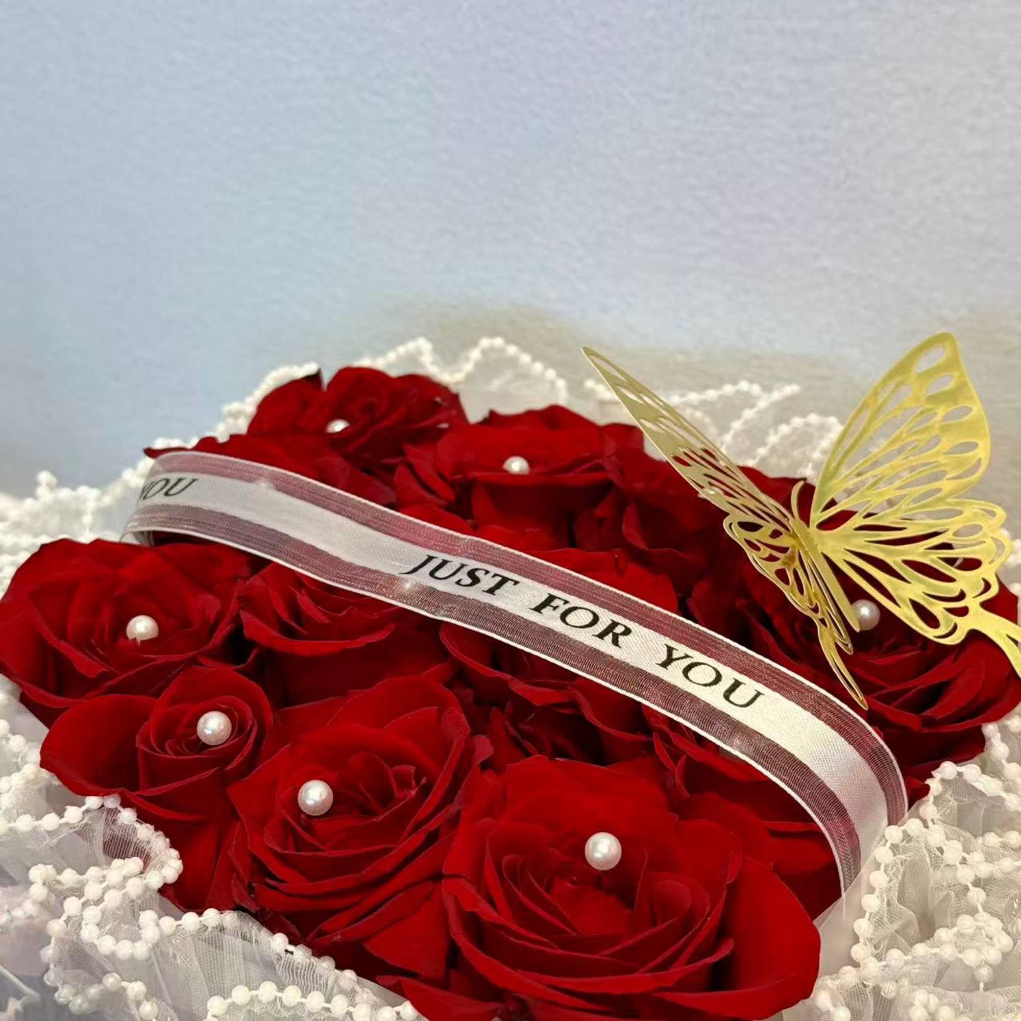 Red rose bouquet with a "Just For You" ribbon and butterfly decoration