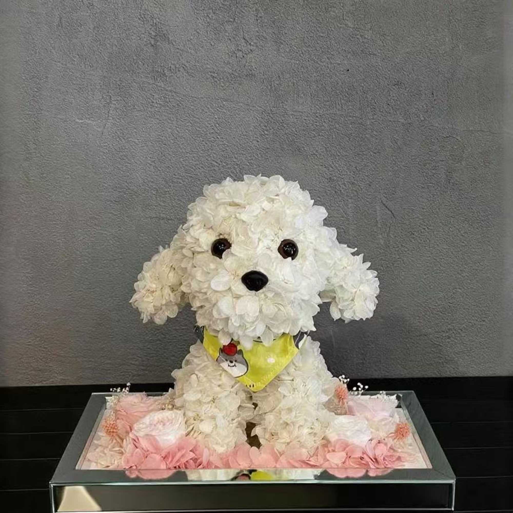 White flower-covered dog figurine in a mirrored tray with pink flowers