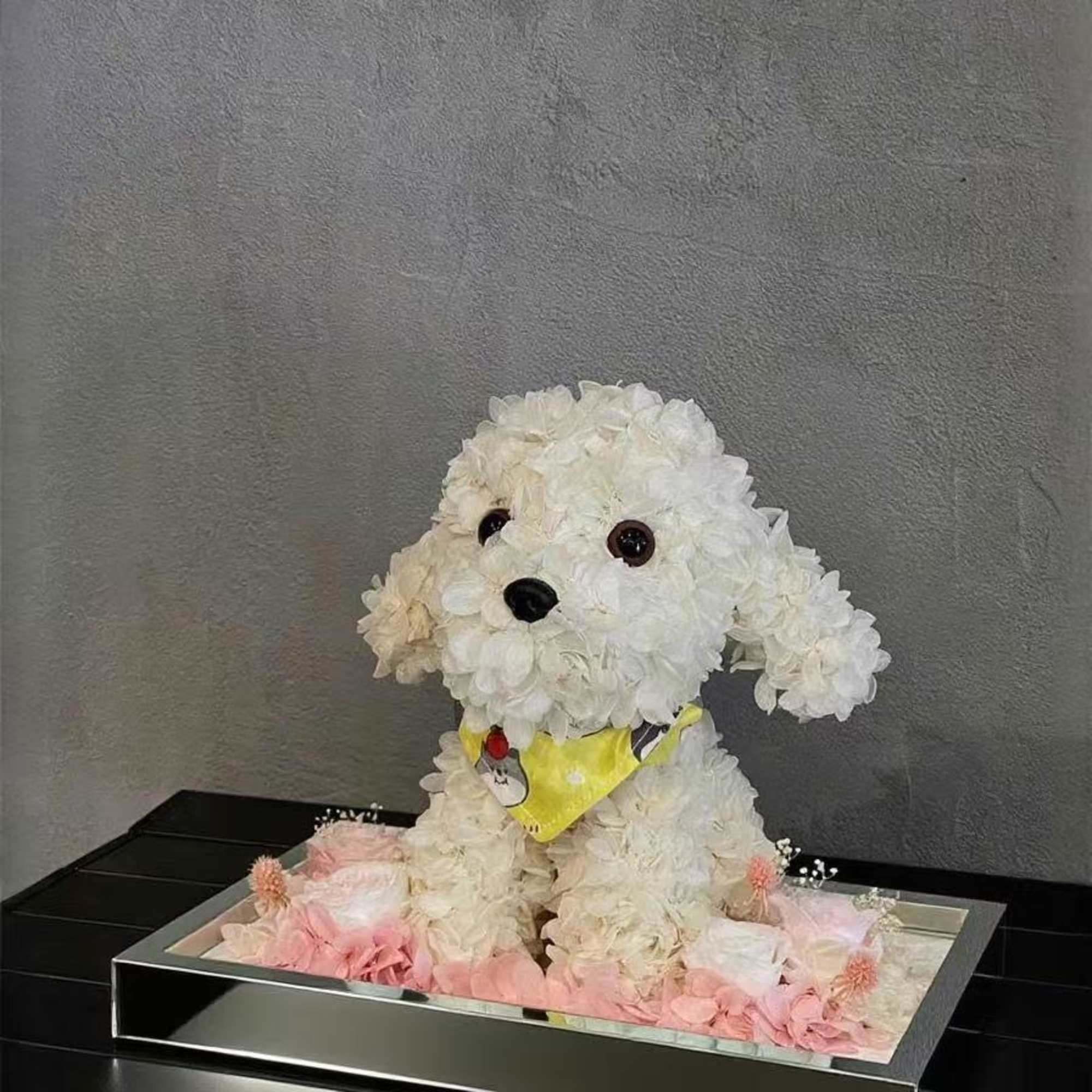 White flower dog sculpture in a mirrored tray with pink accents