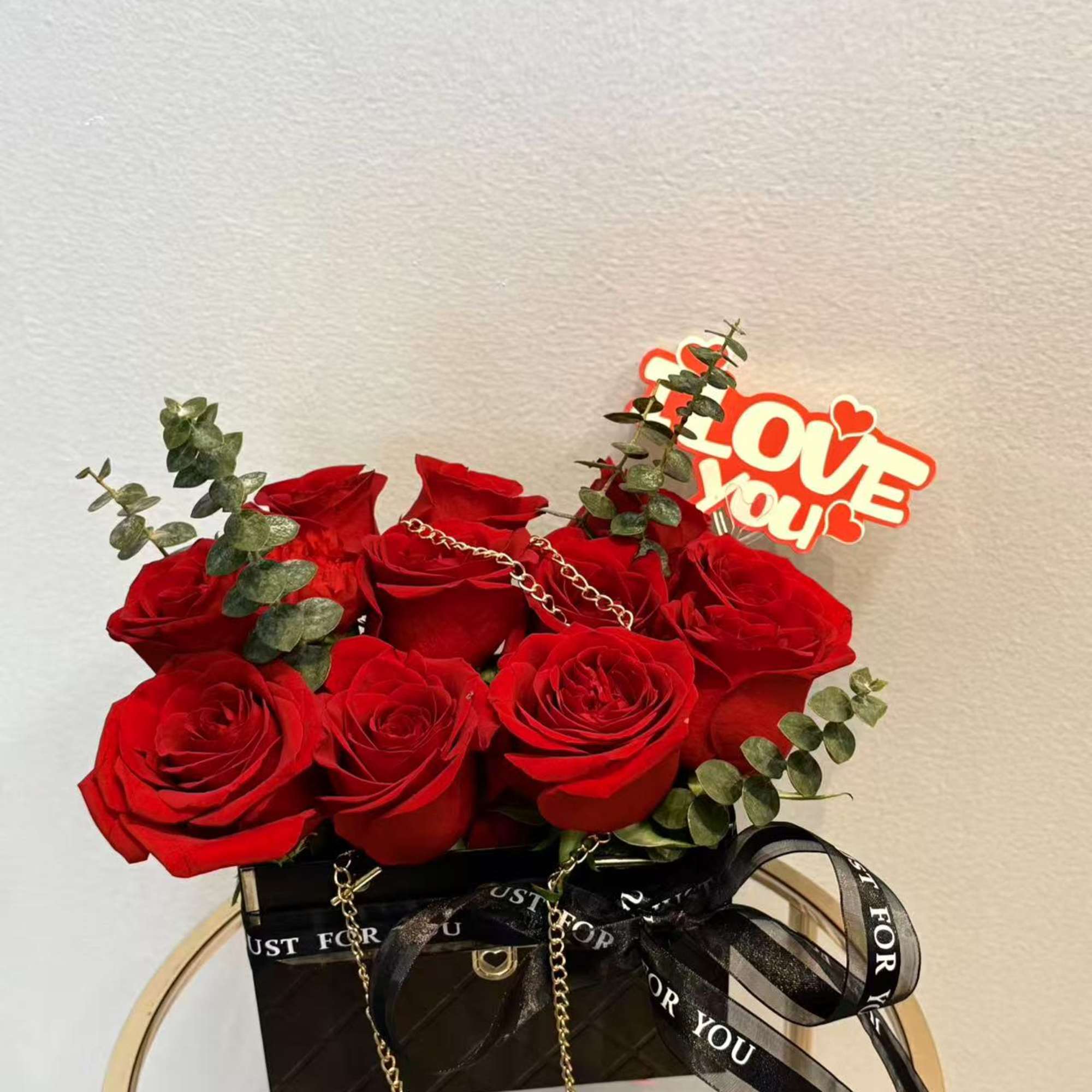 Red roses in a black gift box with a "Love You" topper
