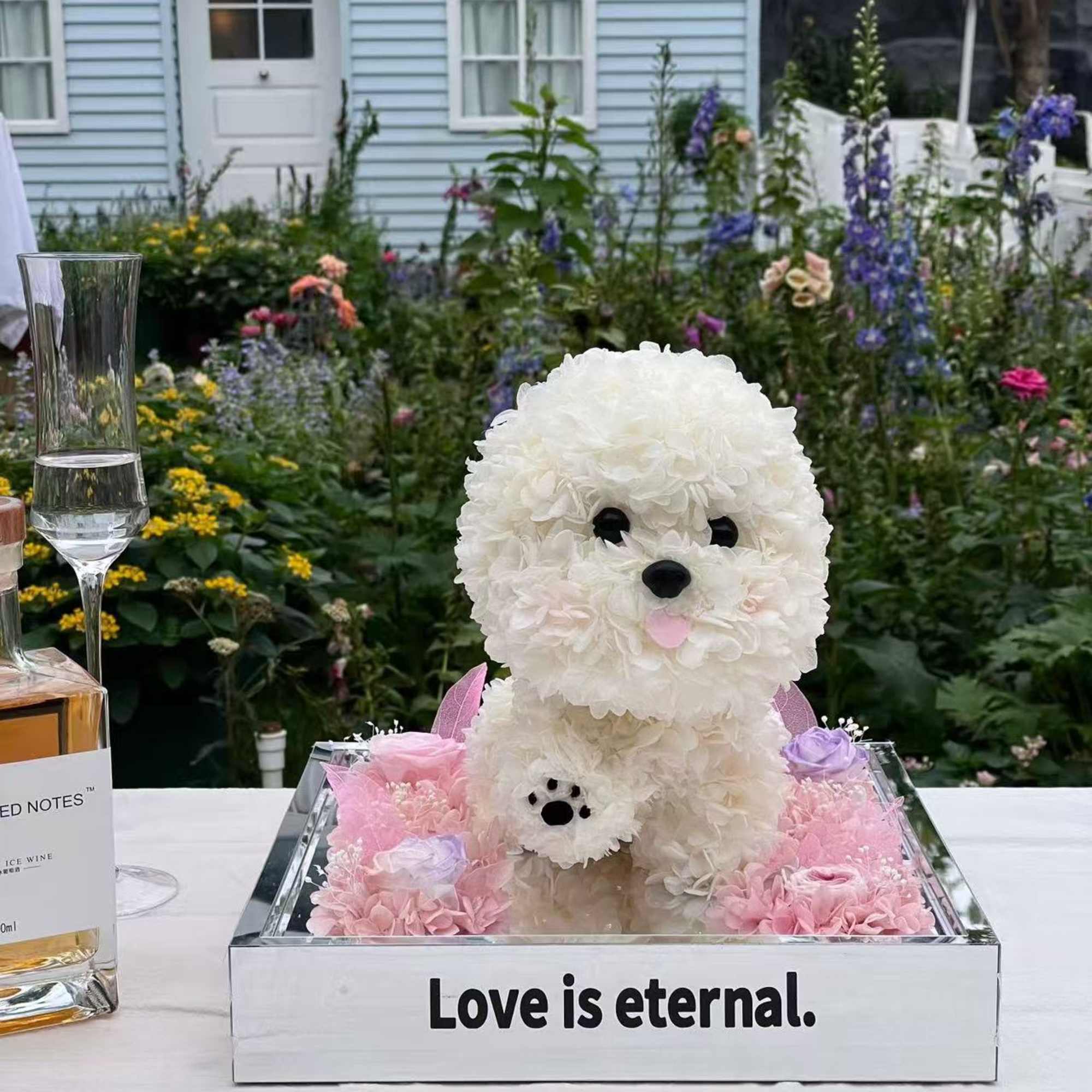White floral dog sculpture in a mirrored box with pink flowers