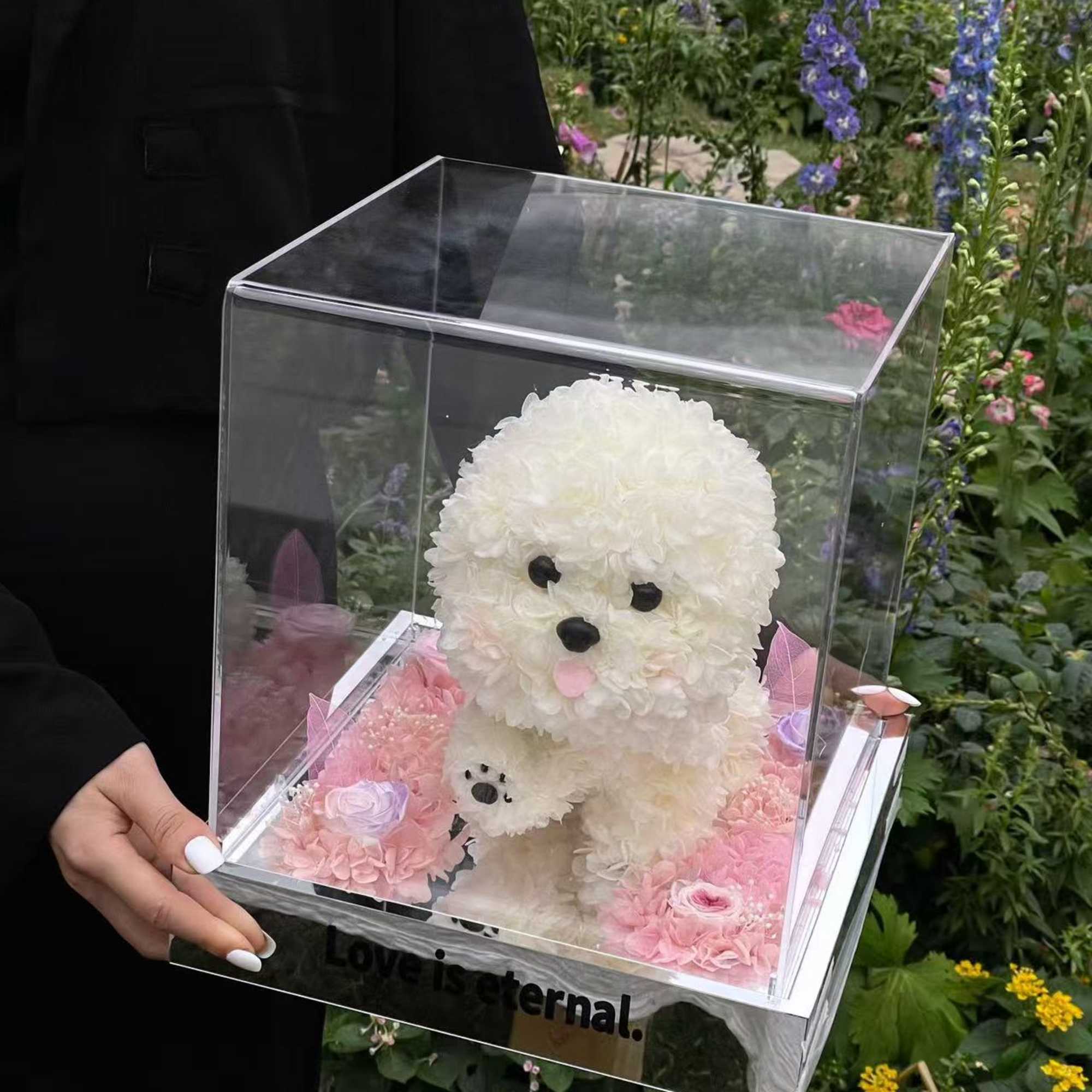 White floral dog figure in a clear display box with pink flowers