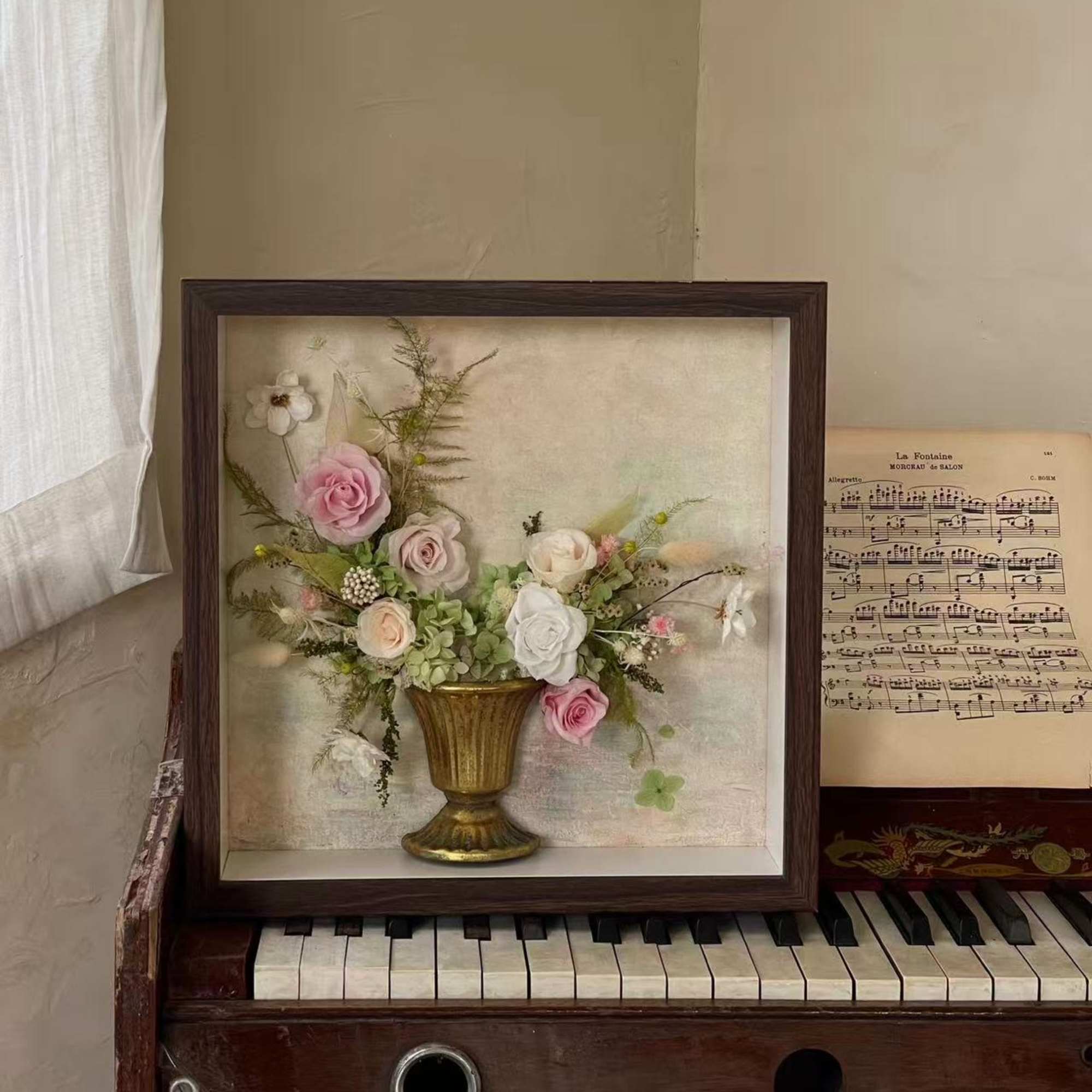 Framed floral arrangement with pink and white roses in a gold vase