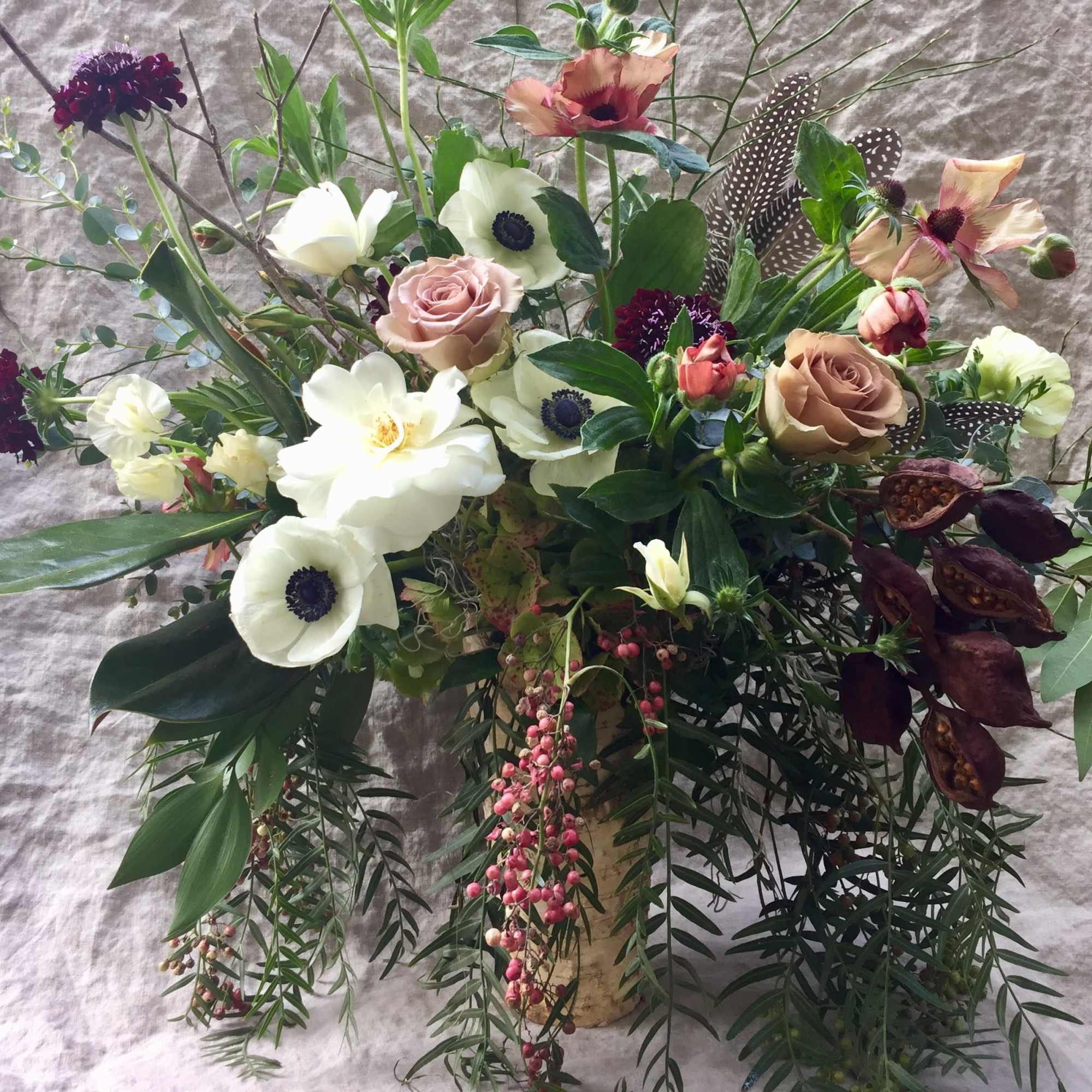 Mixed floral arrangement with white anemones and blush roses in a vase