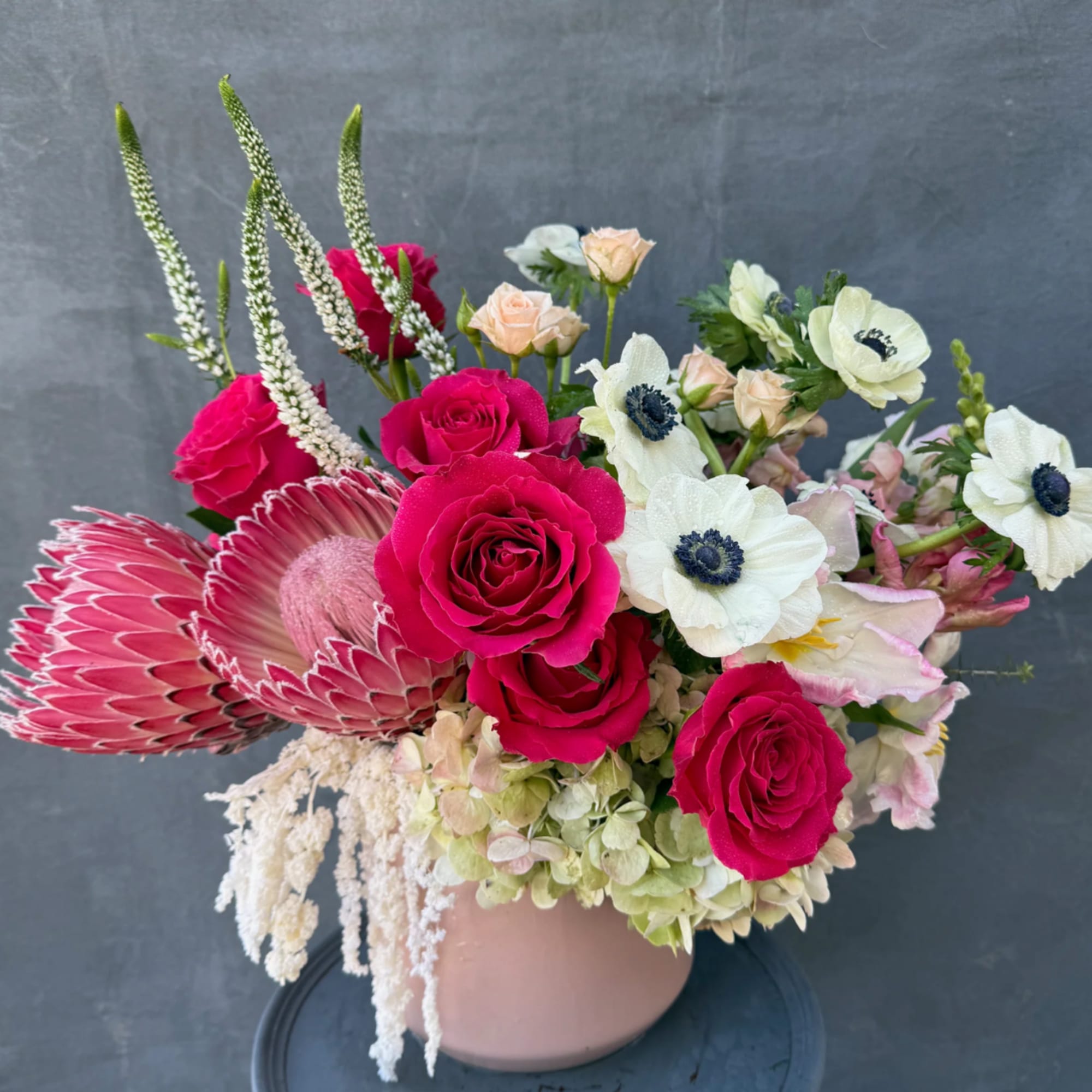 Pink roses and white anemones in a blush vase