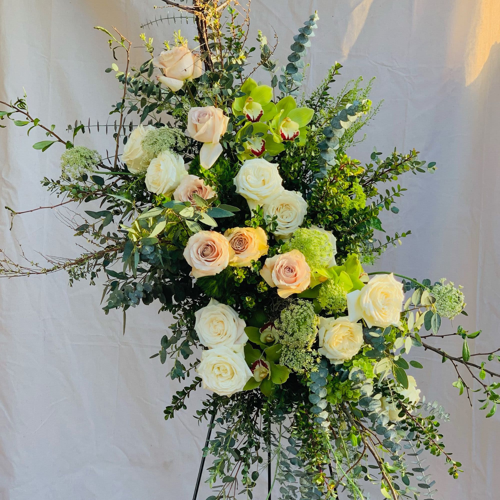 Tall floral spray with white and blush roses and green orchids