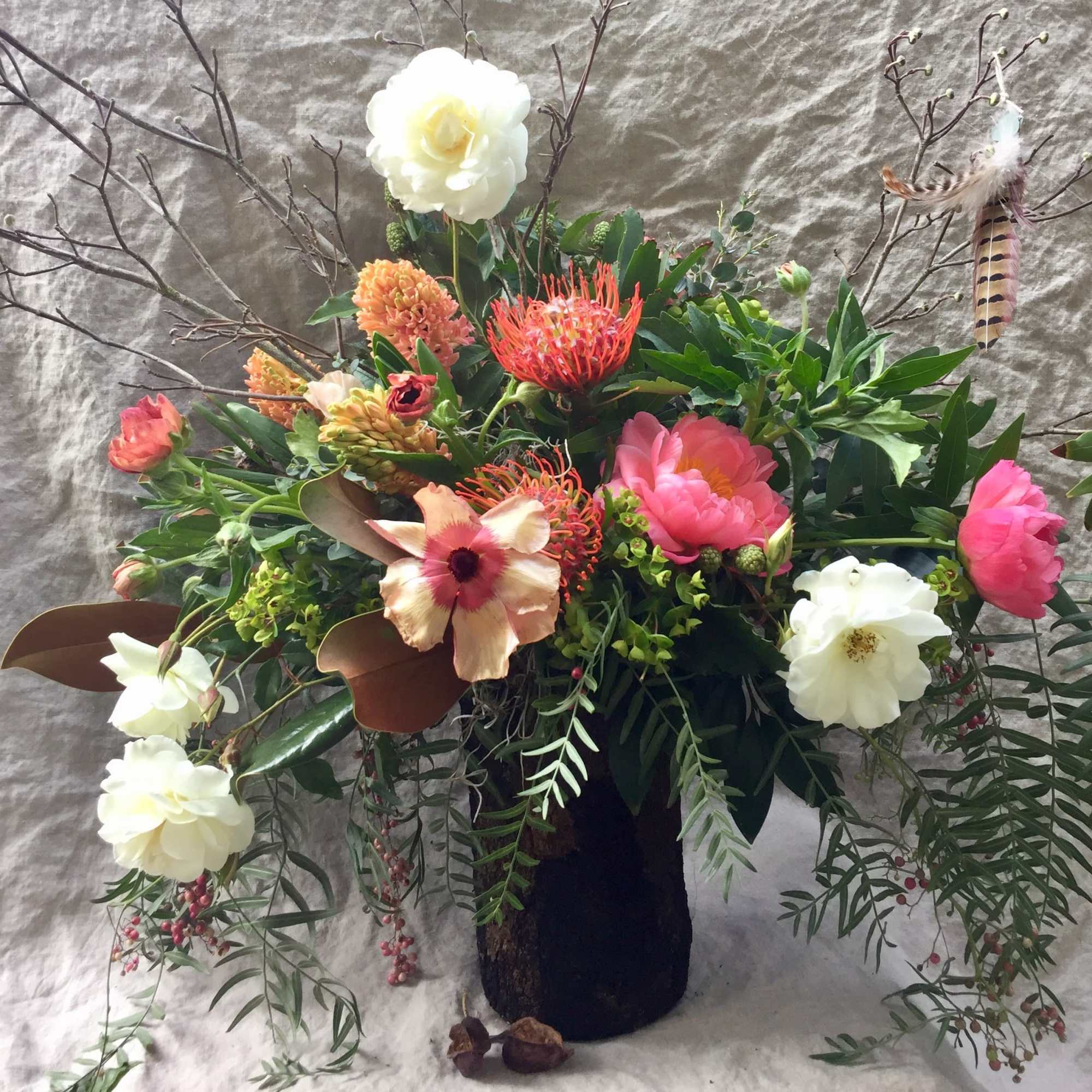 Mixed floral arrangement in a dark vase with white, pink, and orange blooms