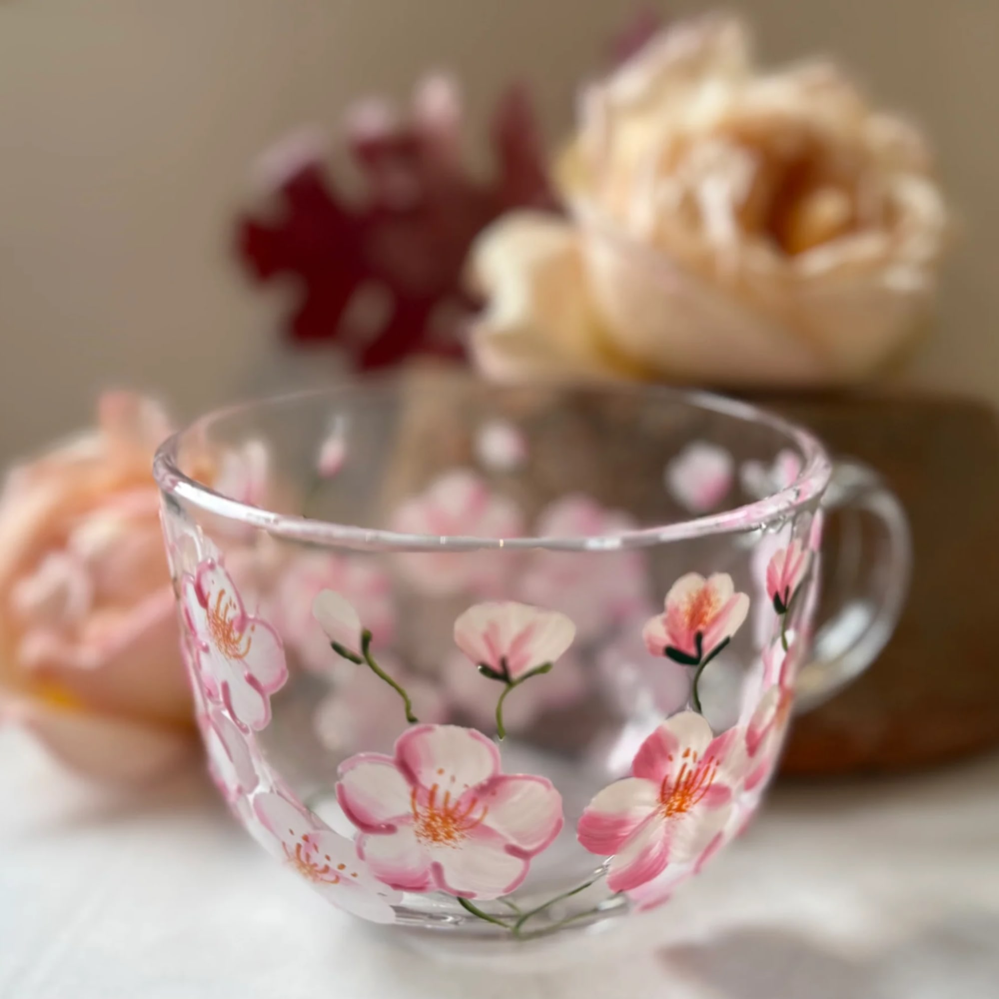 Clear glass cup with pink cherry blossom design
