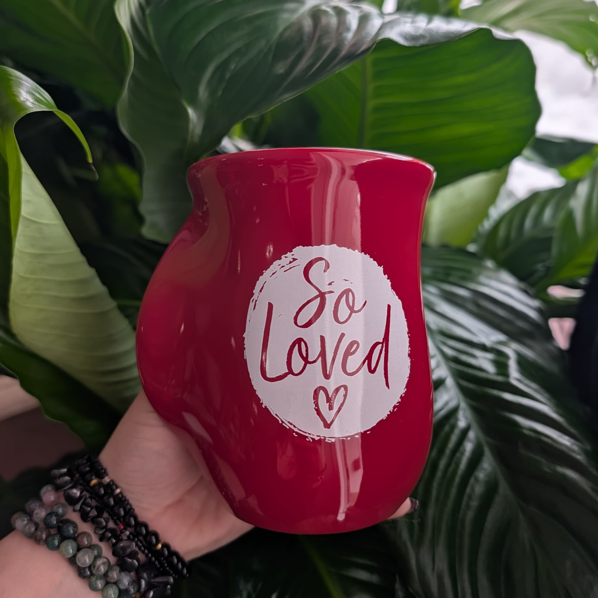 Red memorial candle holder with "So Loved" text
