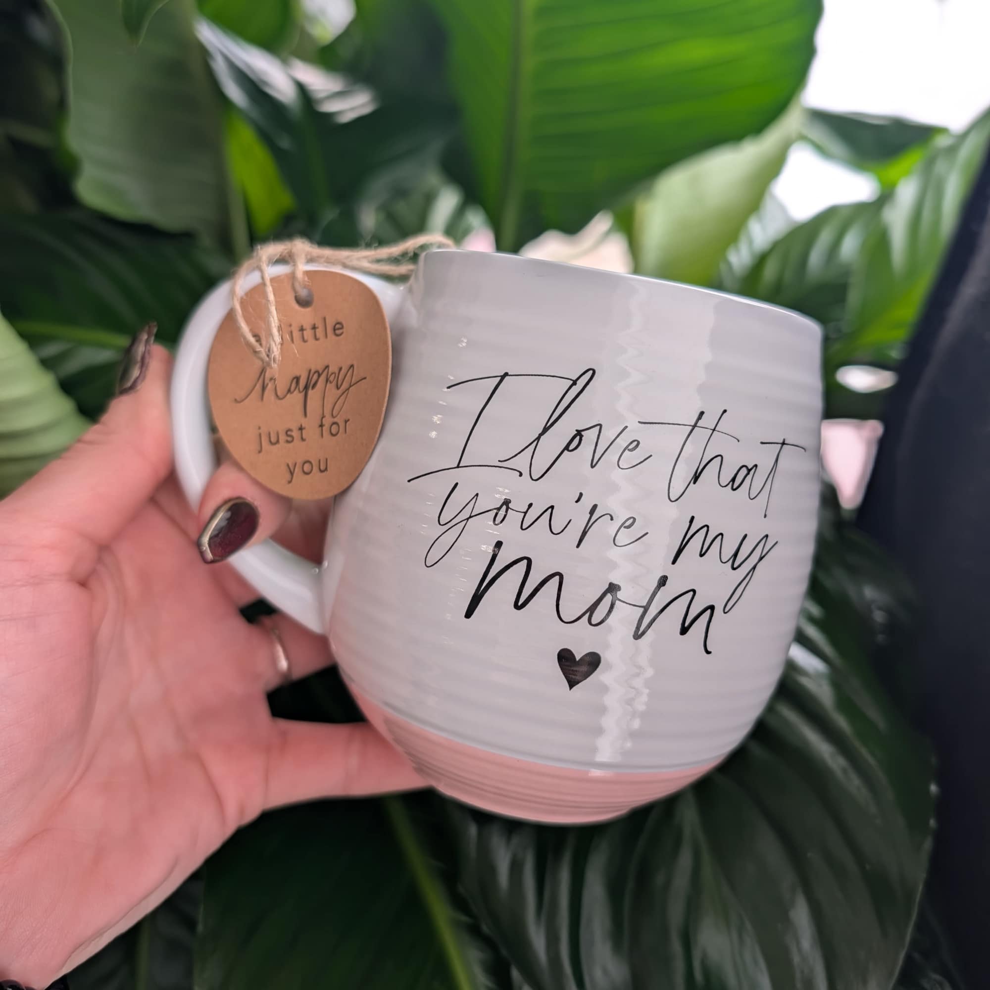 White mug with "I love that you're my mom" text and a hanging tag