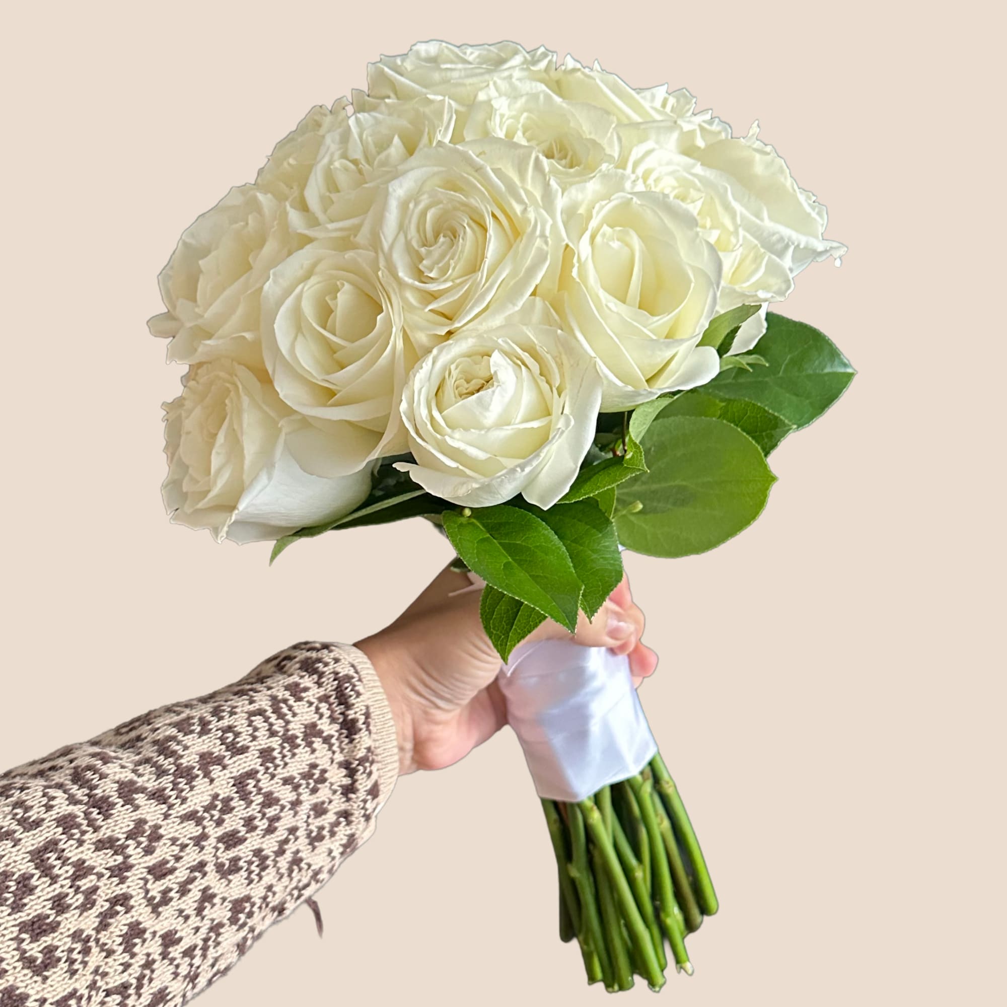Bouquet of white roses with green leaves, wrapped at the stems