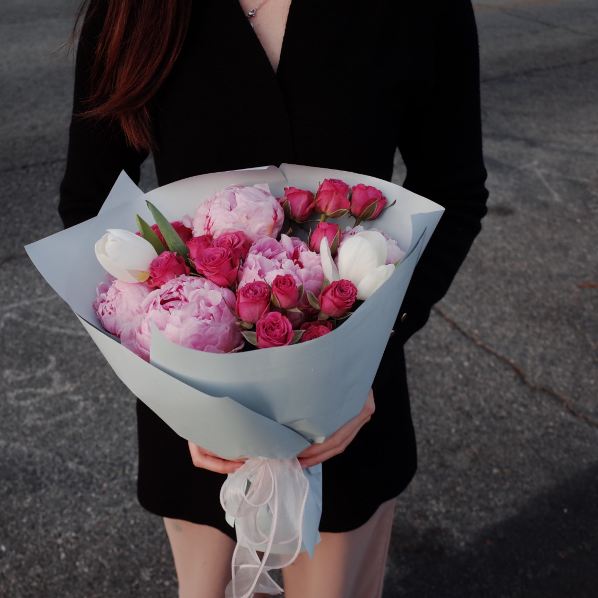 Pink and white bouquet with roses and tulips wrapped in pale paper