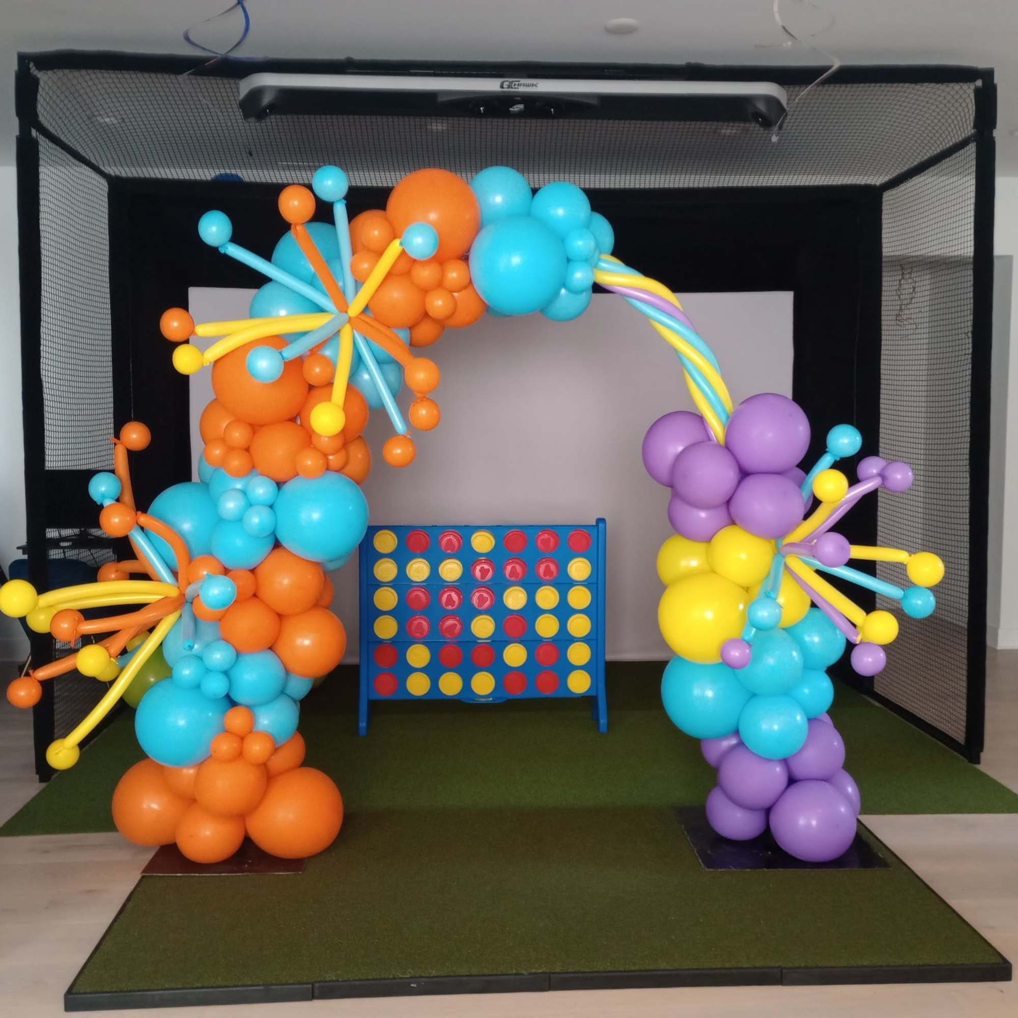 Colorful balloon arch around a Connect Four game board