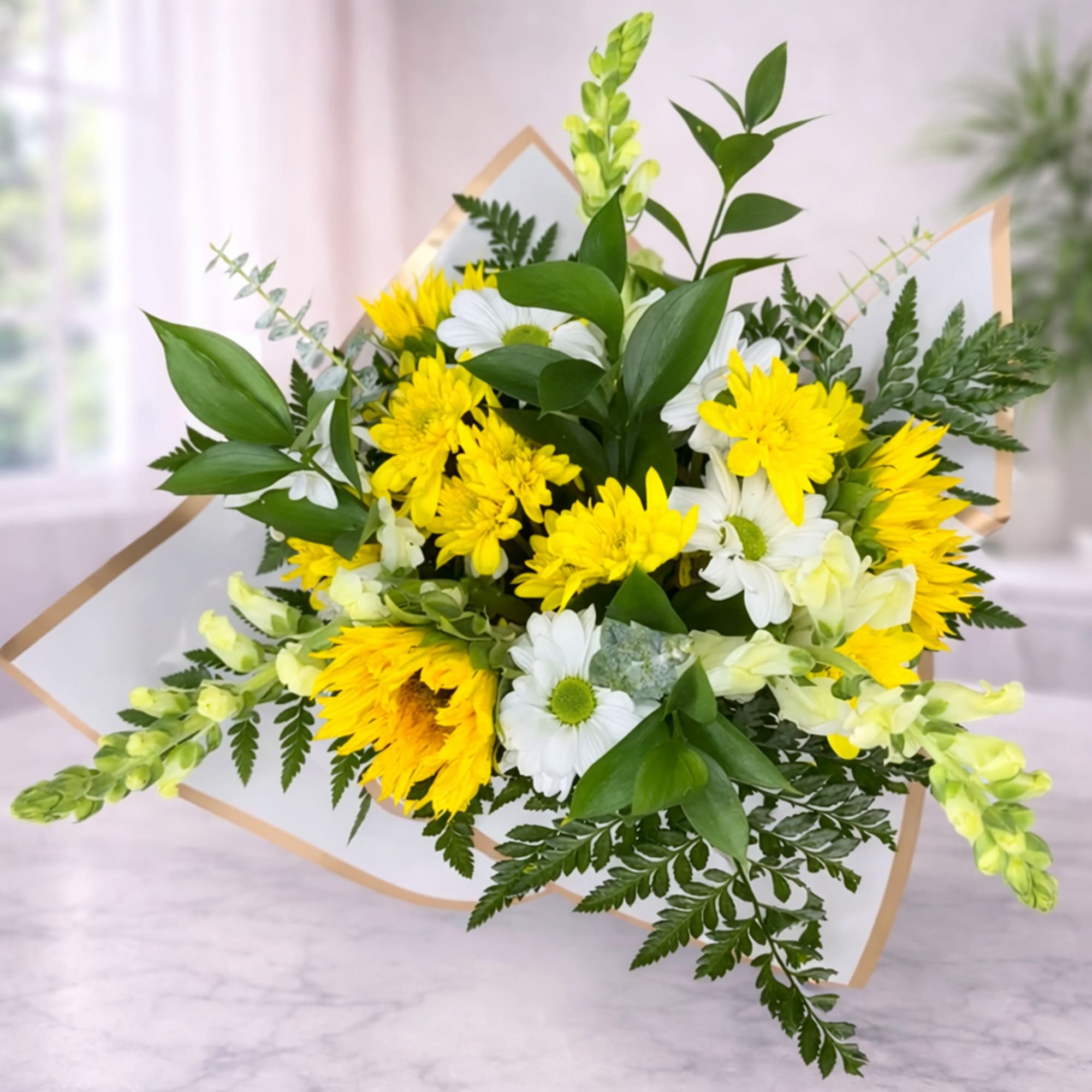 Bouquet of yellow and white flowers with greenery in paper wrap