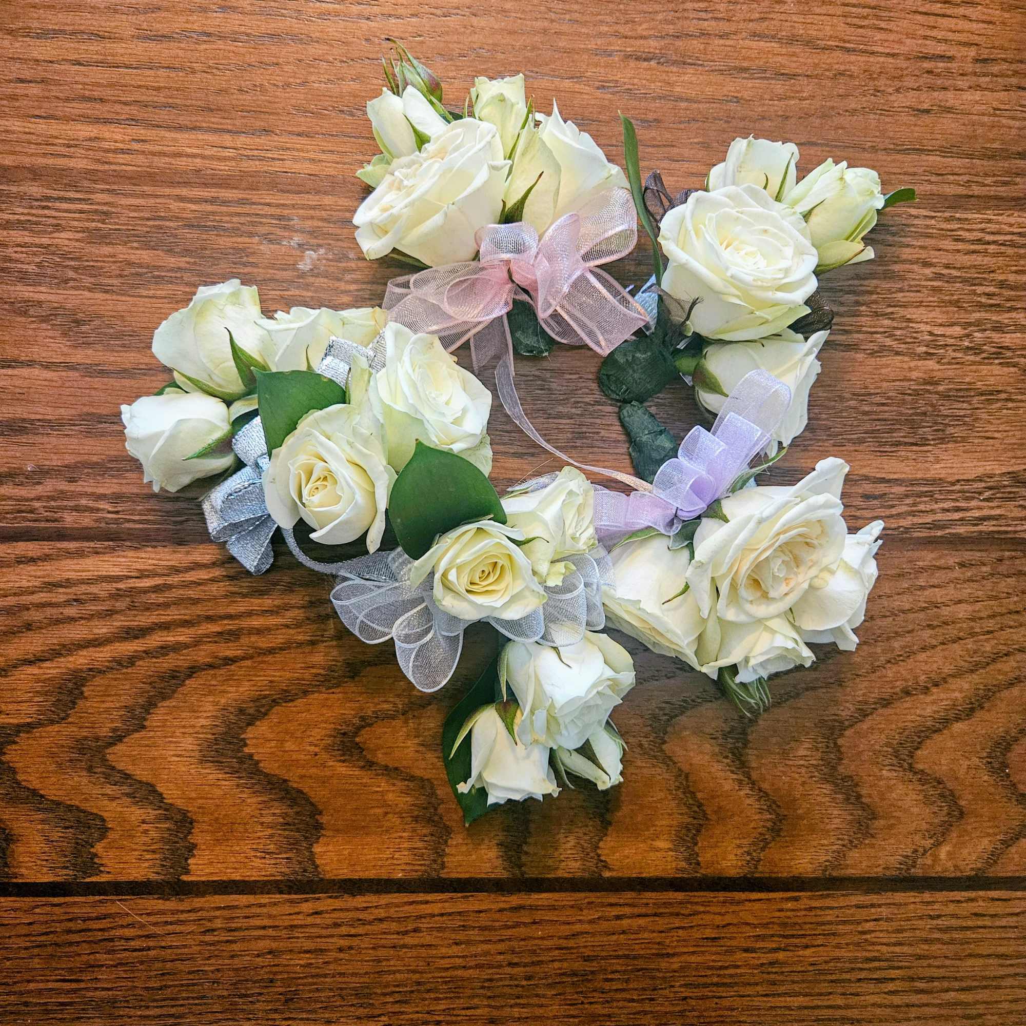 A cluster of white roses tied with a silver ribbon creates a, photo 2 of 2