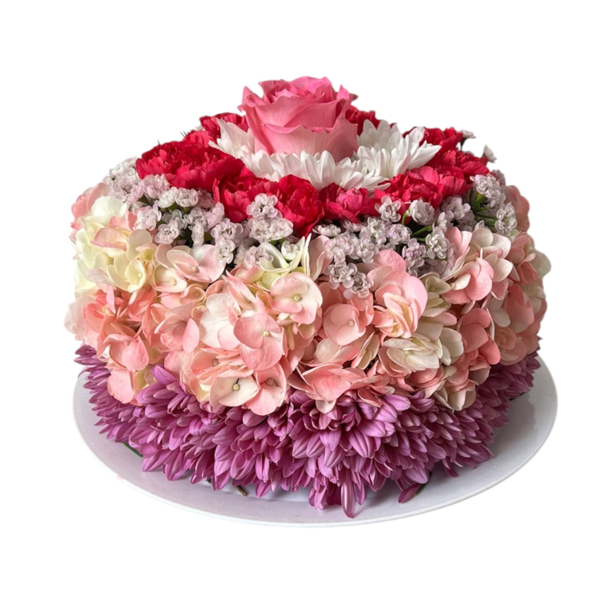 Round floral cake with pink, red, white, and purple flowers on a white plate