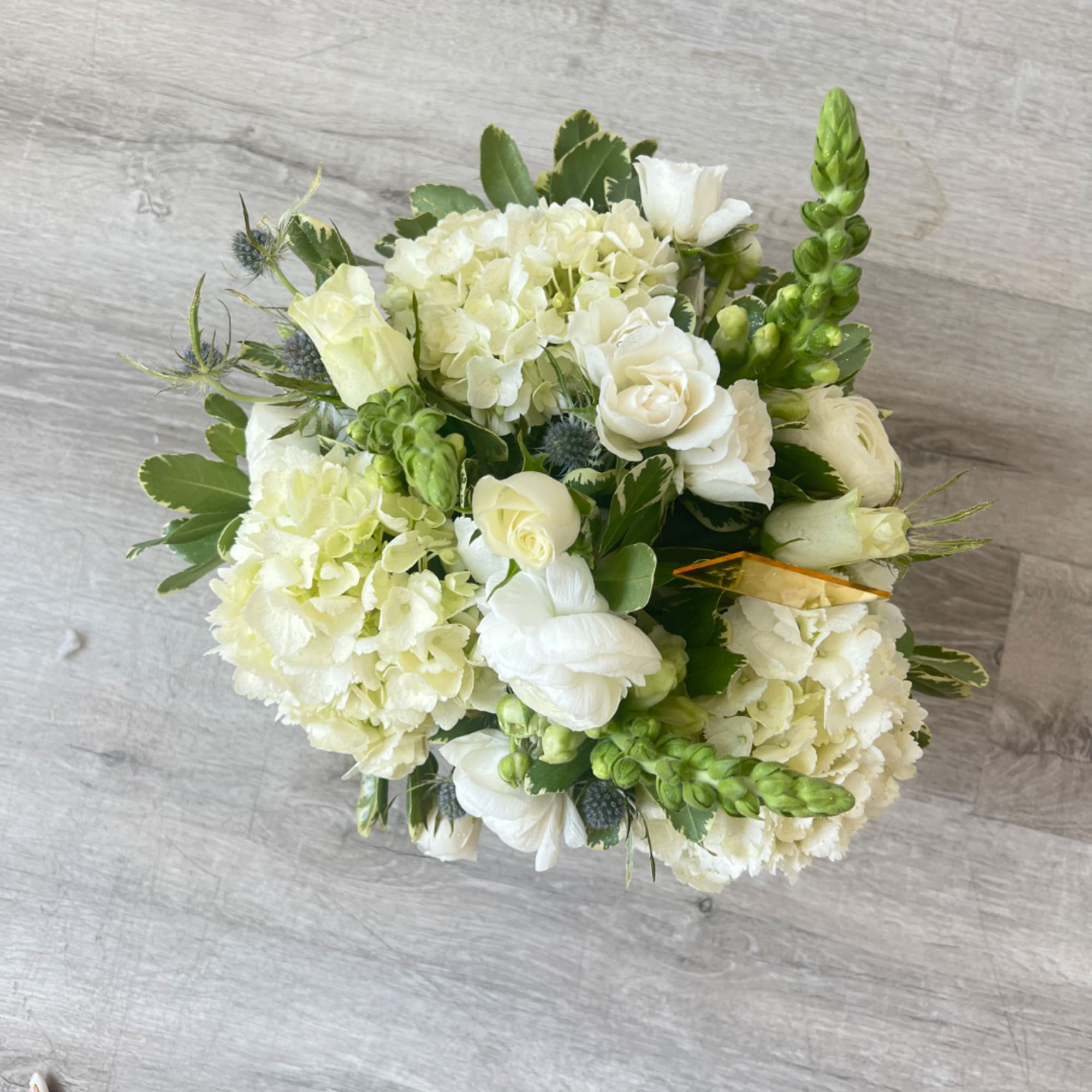 White and pale green bouquet with hydrangeas, roses, and snapdragons