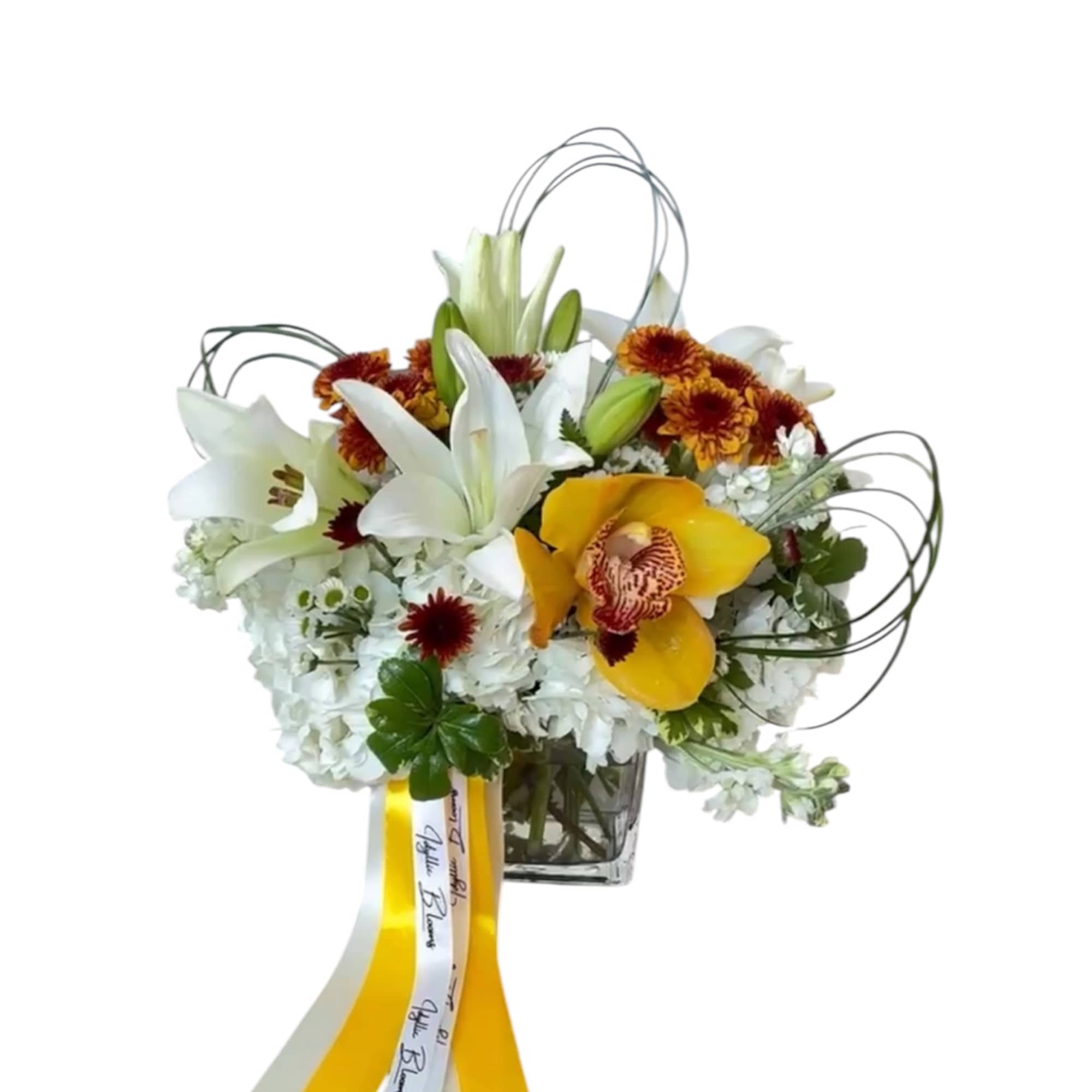 White lilies and yellow orchids in a glass vase with ribbon streamers