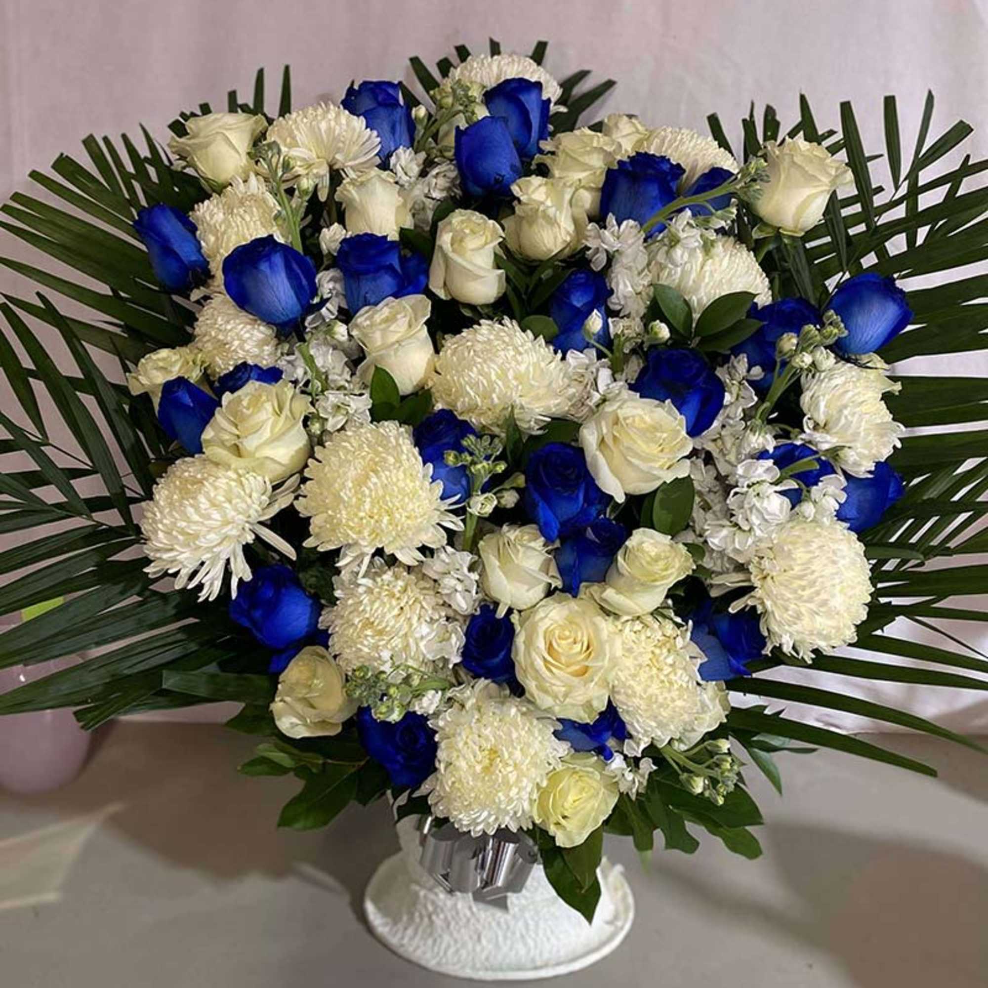 Blue and white rose bouquet with white mums in a vase