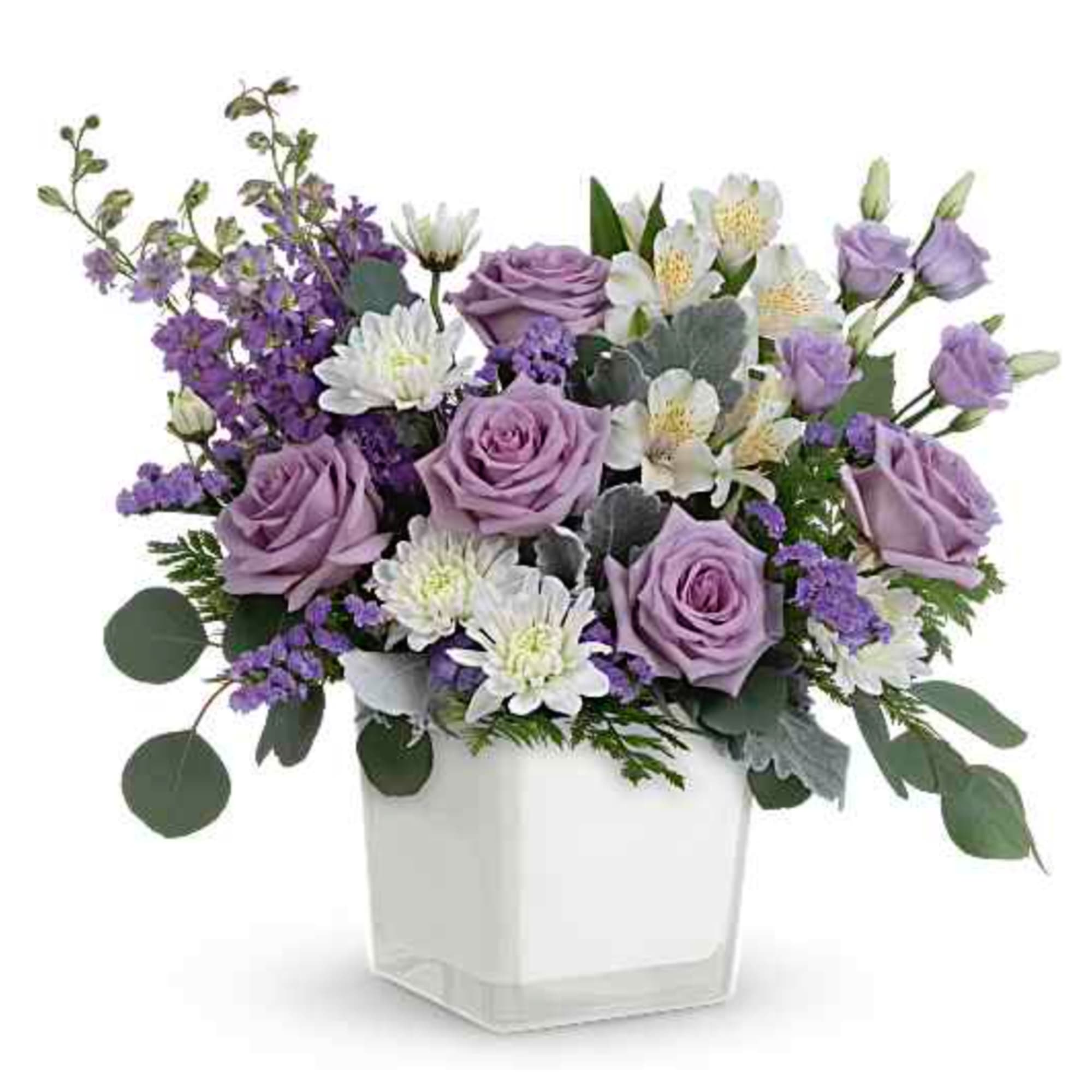 Lavender roses and white flowers in a clear square vase