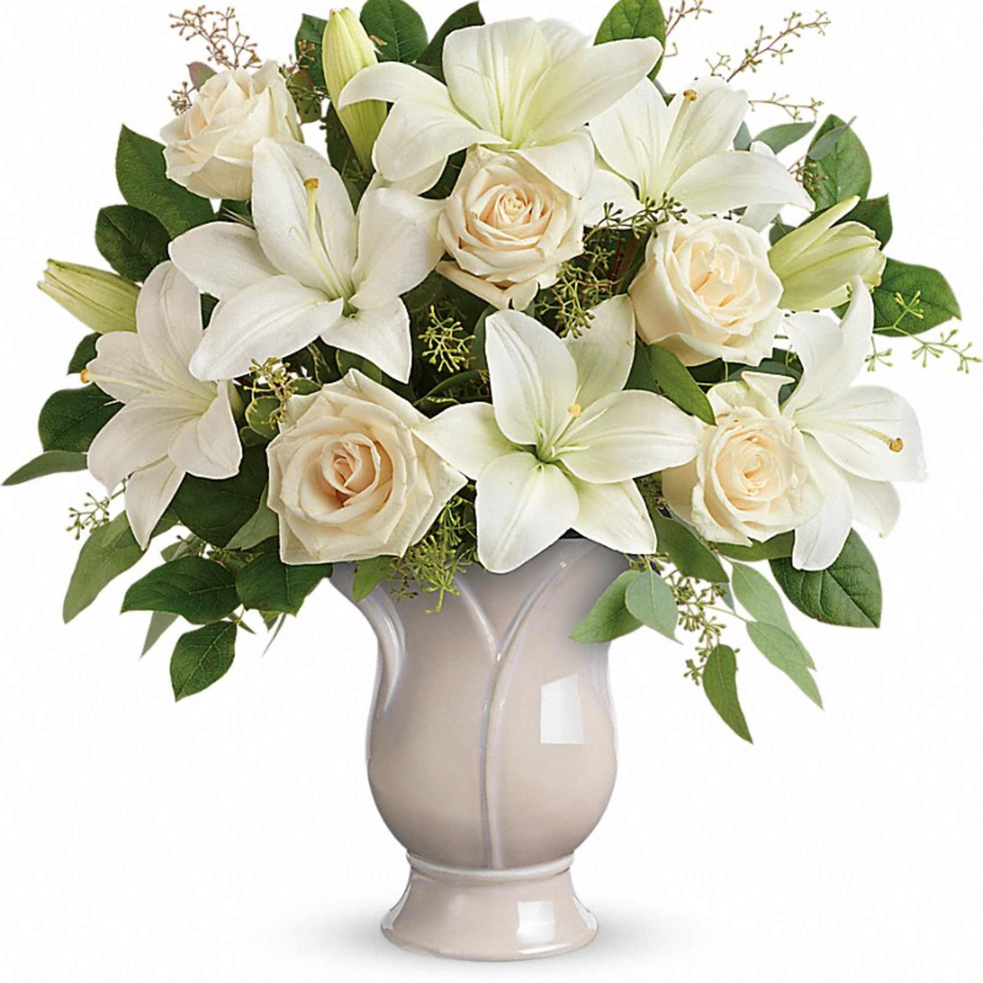 White lilies and cream roses arranged in a beige vase