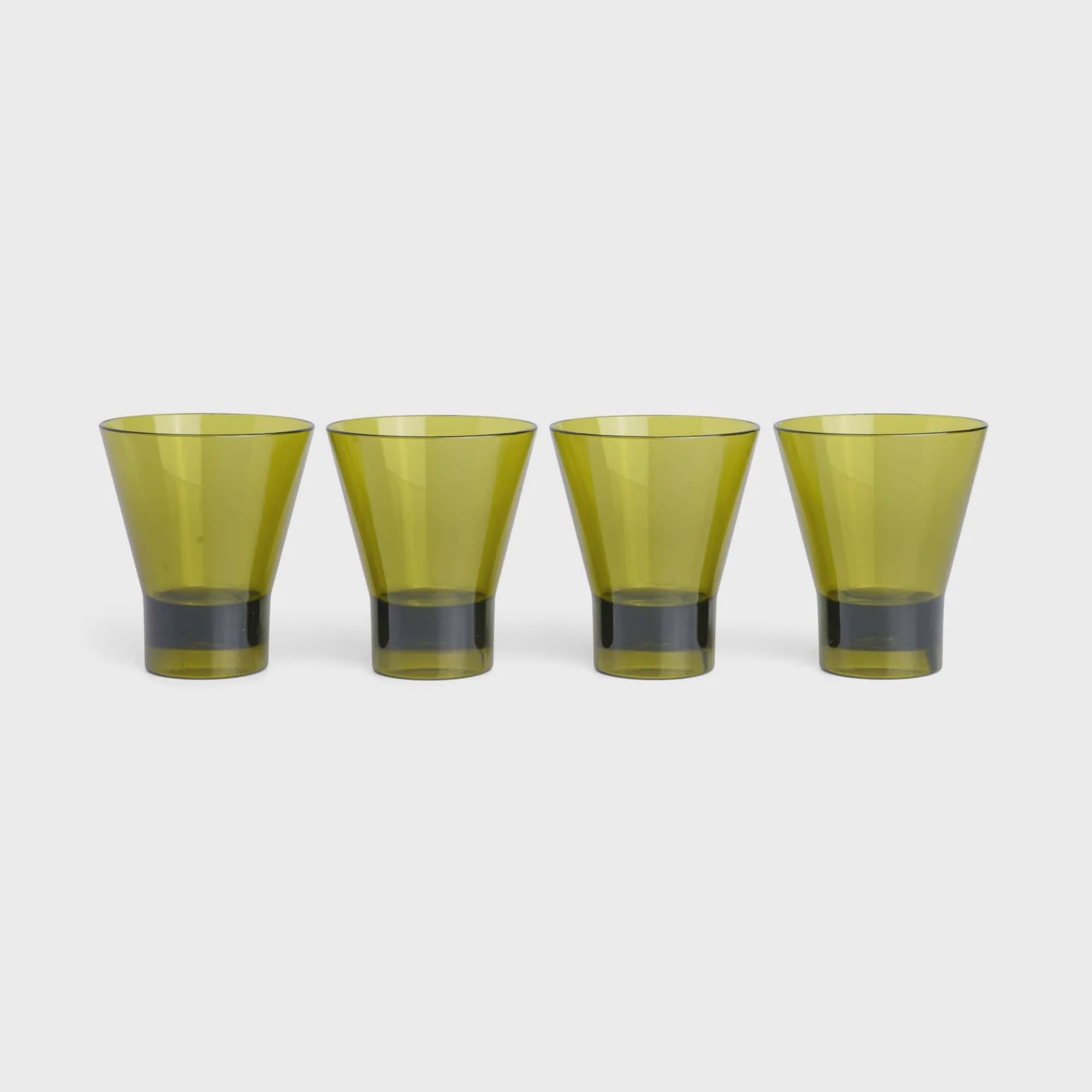 Four yellow-green drinking glasses on a white background