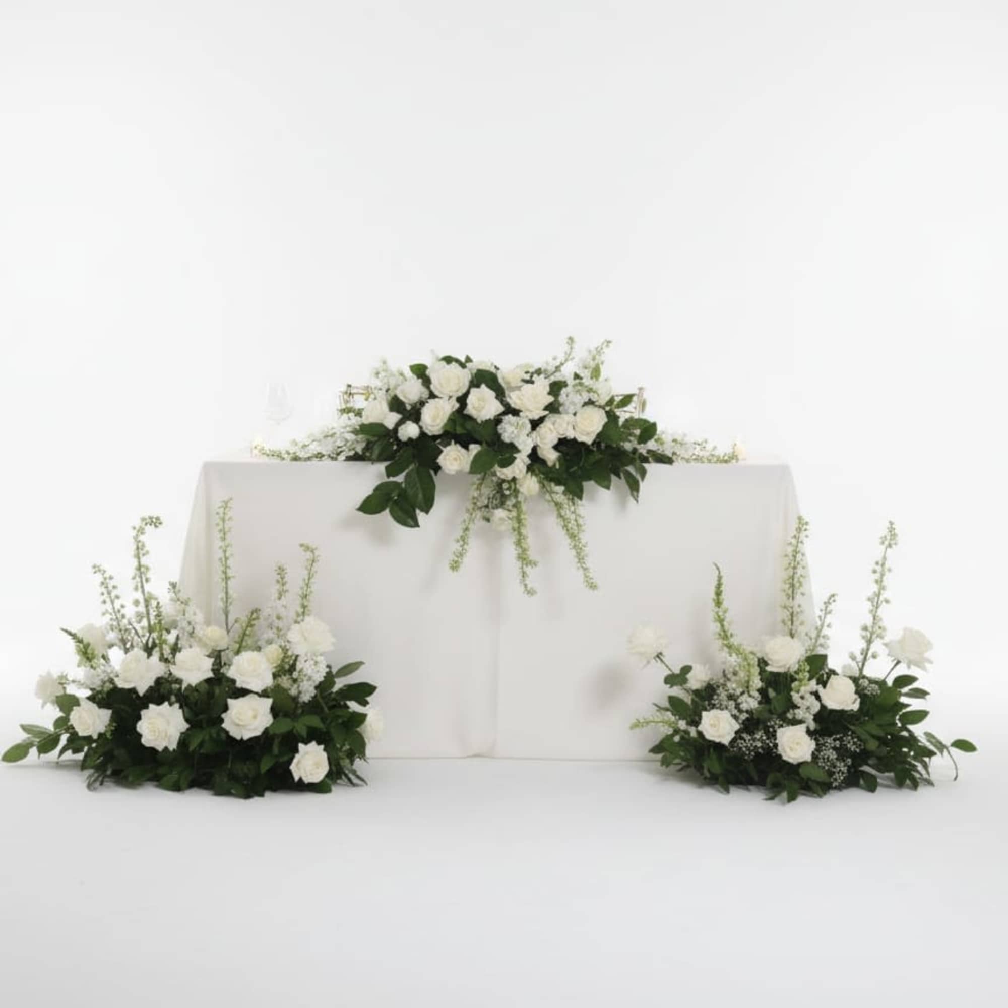 This romantic swetheart table meade with fresh white blooms, including roses, chrysanthemums