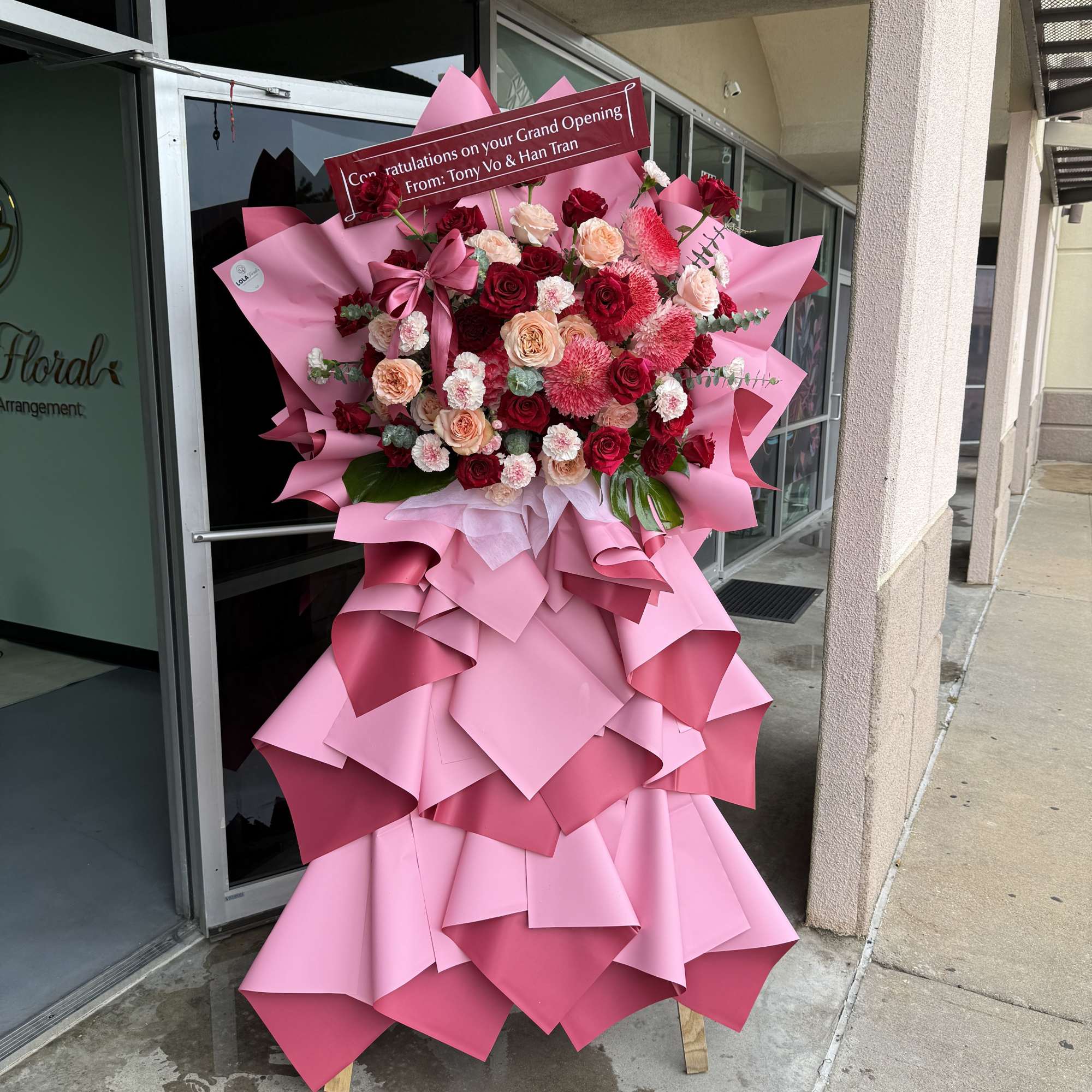 Red, blush, peach and white roses and carnations arranged on a wooden