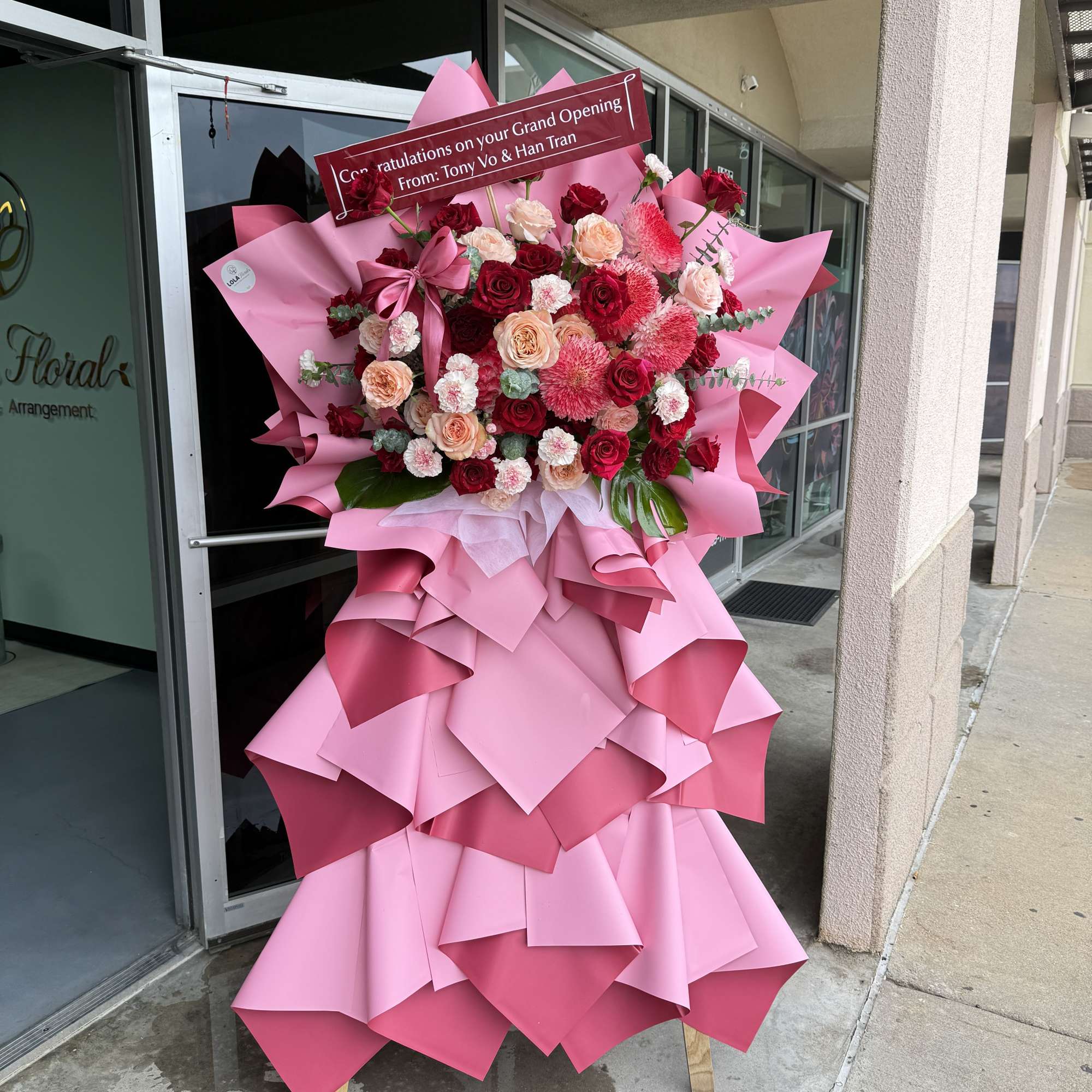 Red, blush, peach and white roses and carnations arranged on a wooden, photo 2 of 2