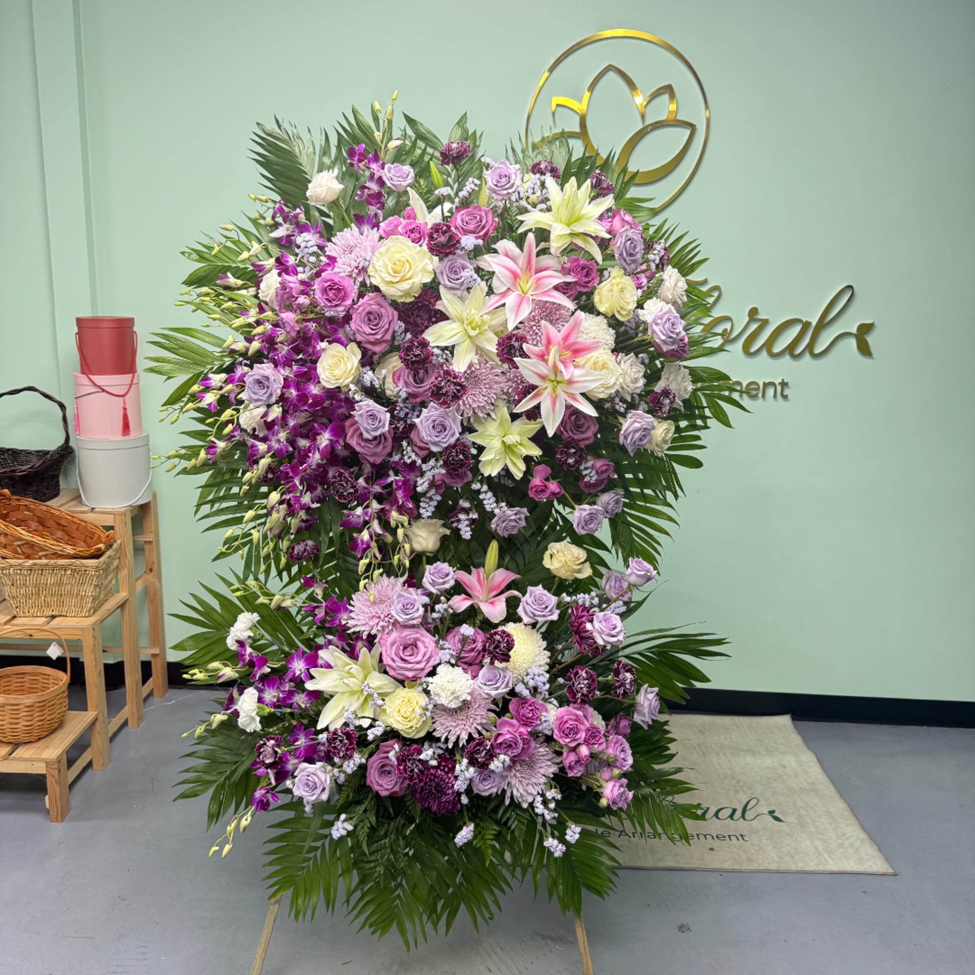 Large standing floral spray with pink, purple, and white blooms