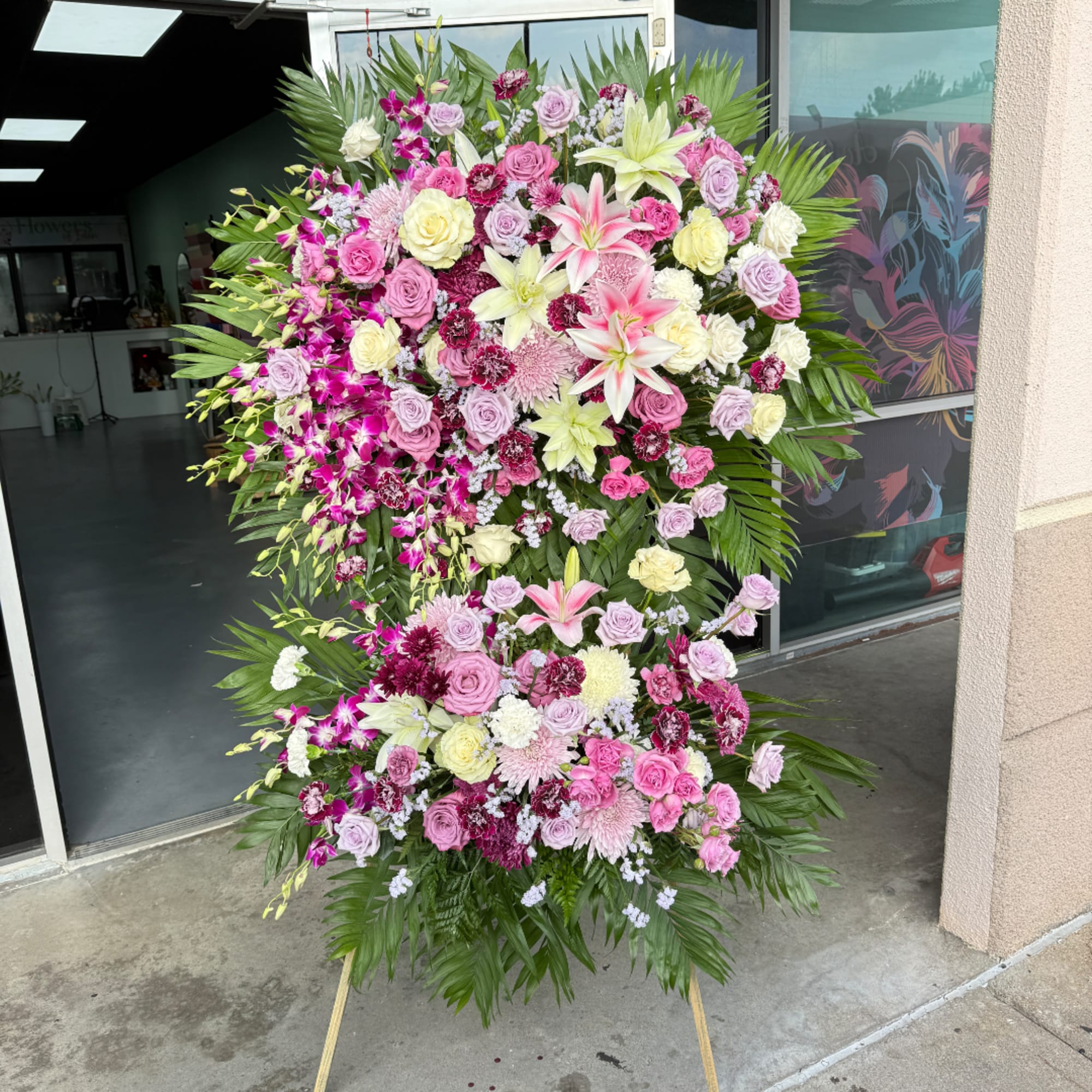 Large standing floral spray with pink, white, and yellow flowers