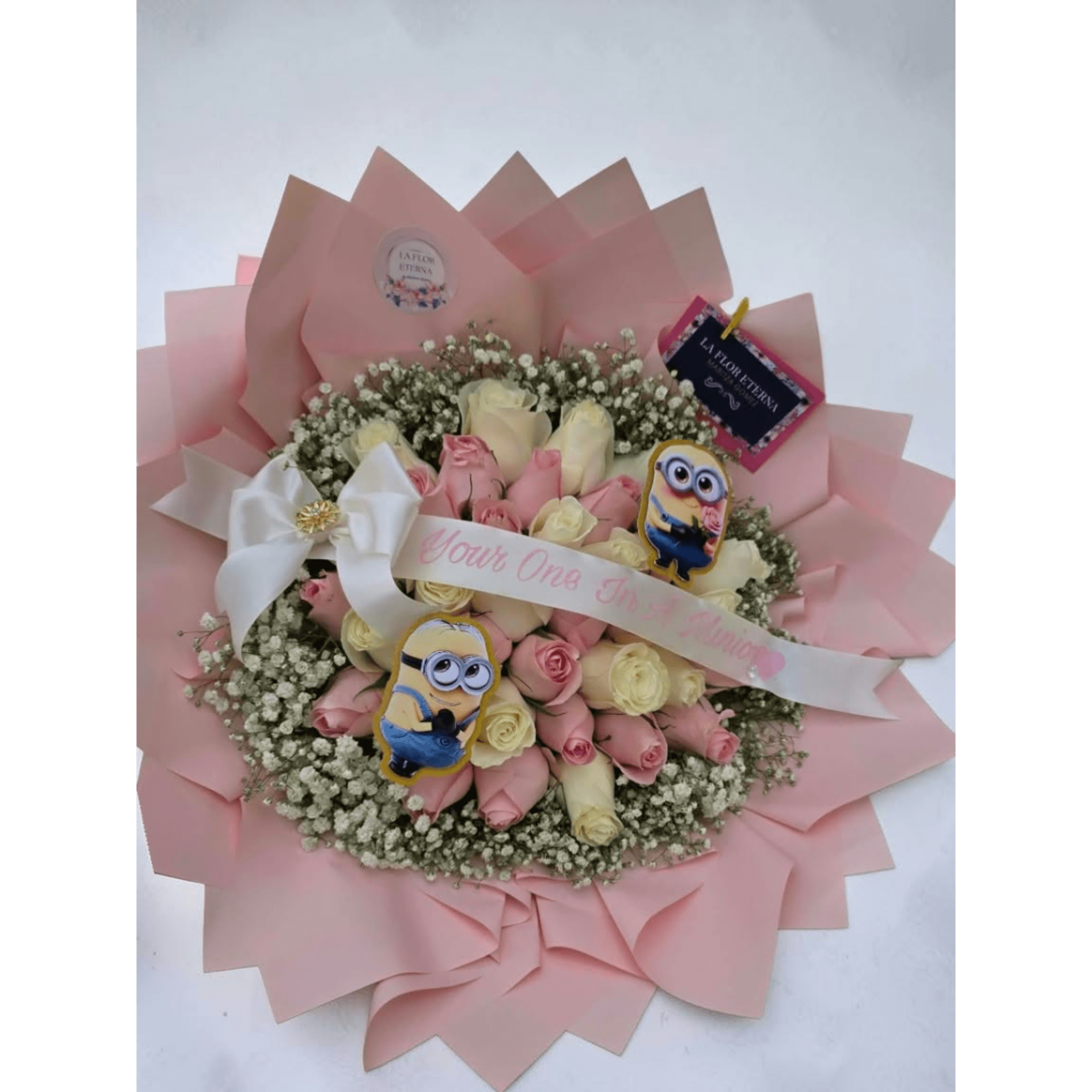 Pink and cream rose bouquet with baby’s breath, ribbon, and cartoon toppers