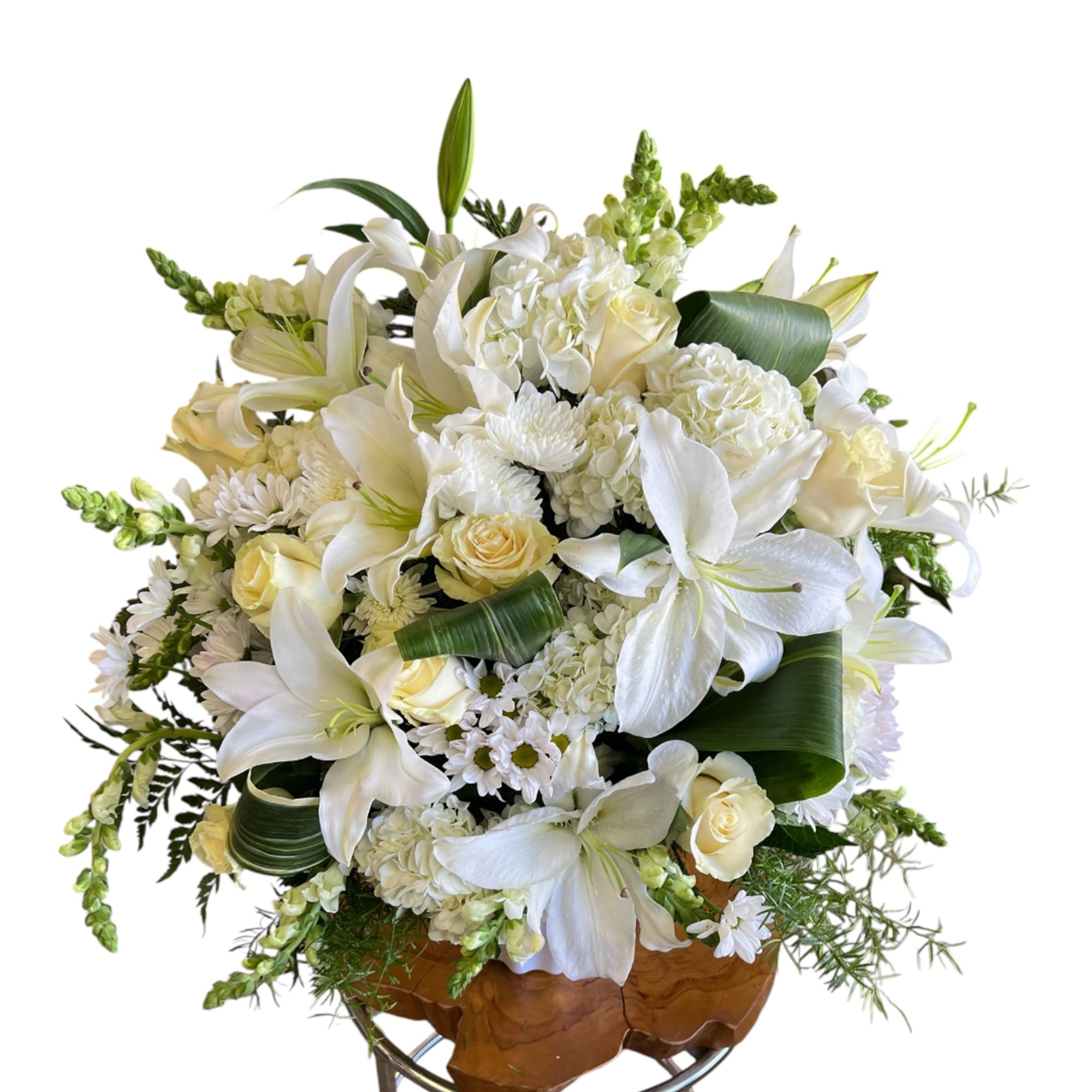 White lilies and roses arranged in a wooden bowl