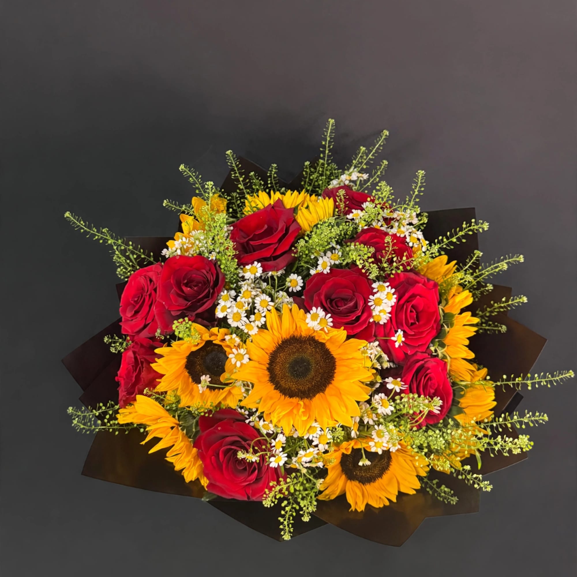 Bouquet of red roses and sunflowers with small white daisies