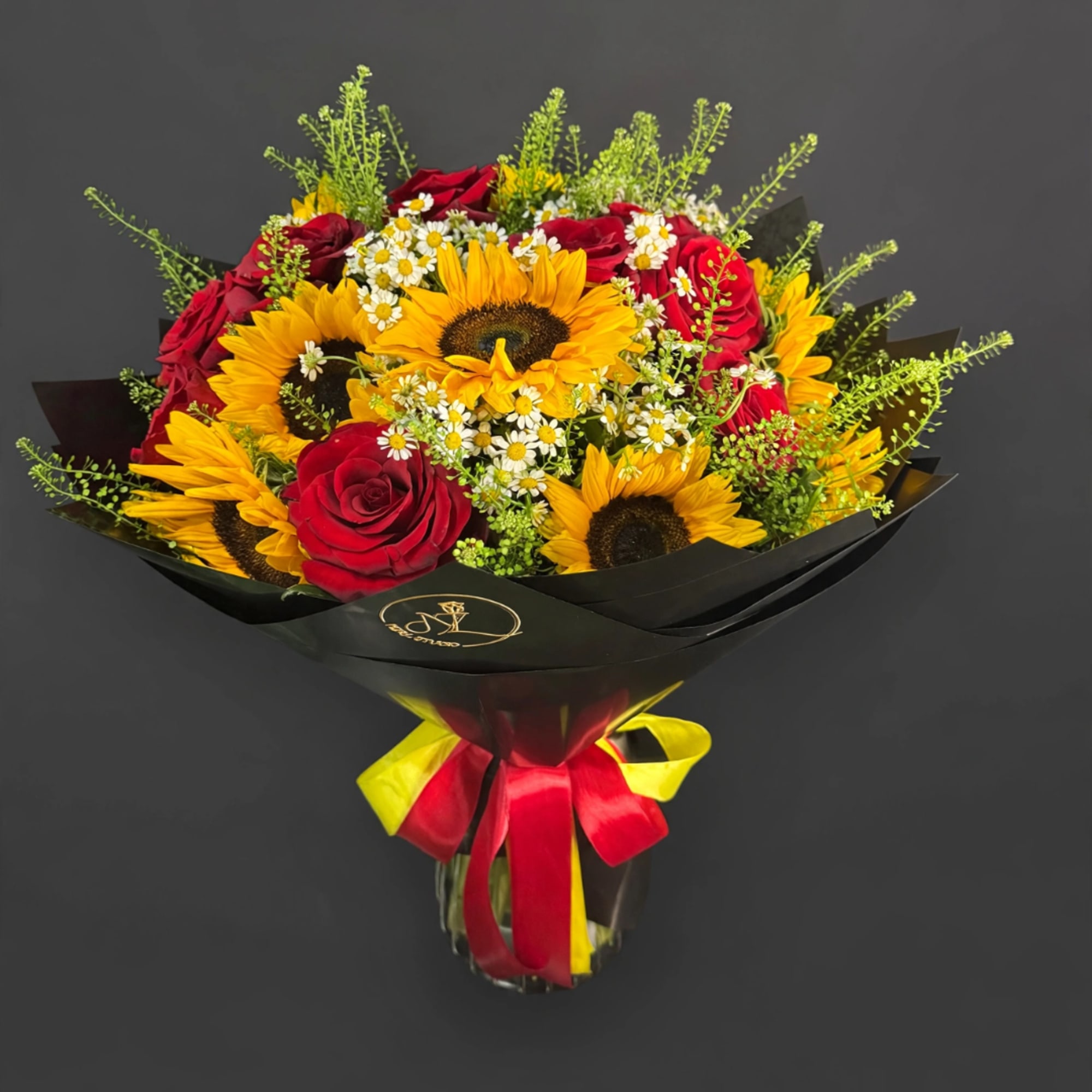 Bouquet of red roses and yellow sunflowers wrapped in black paper with a red and yellow ribbon