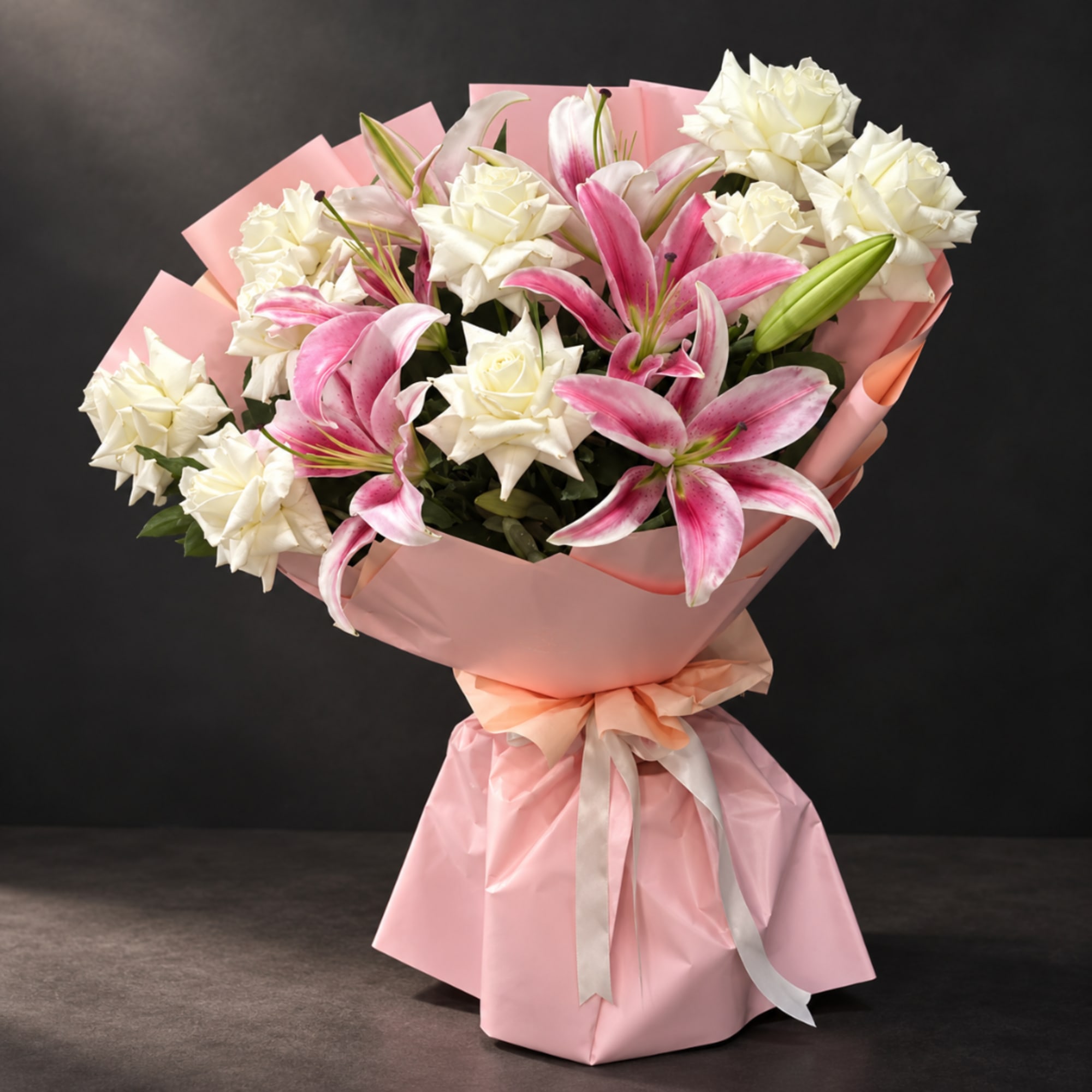 Pink and white bouquet of lilies and roses wrapped in pink paper