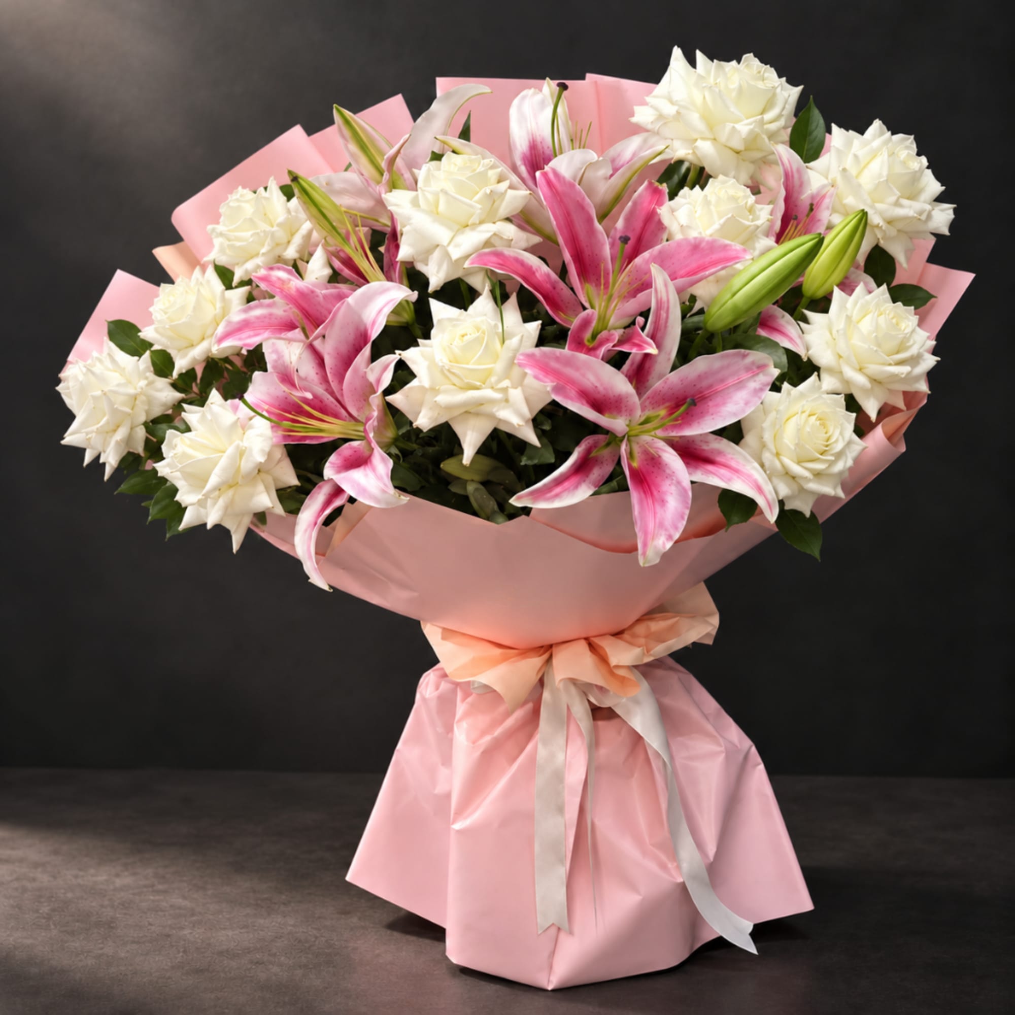 Pink and white bouquet of lilies and roses wrapped in pink paper