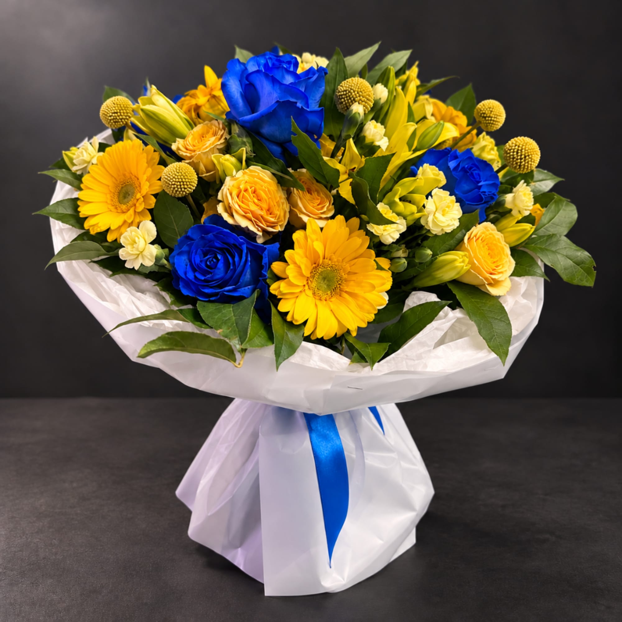 Bouquet of blue roses and yellow gerbera daisies wrapped in white paper