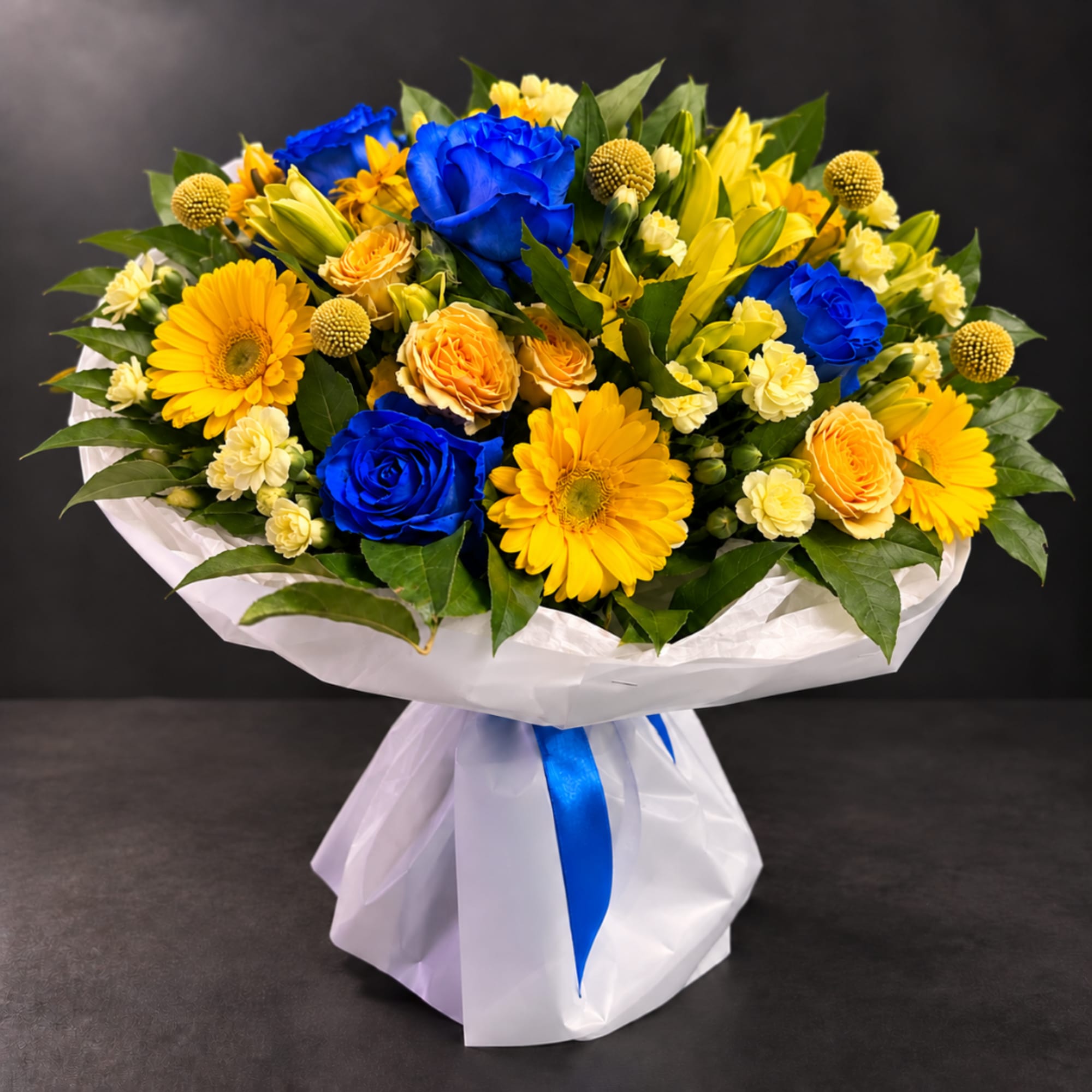 Bouquet of blue roses and yellow gerbera daisies wrapped in white paper