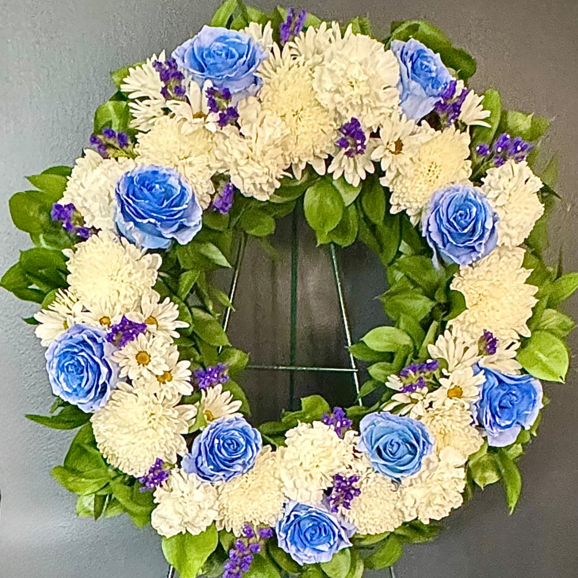 Heart-shaped floral wreath with blue roses and white flowers