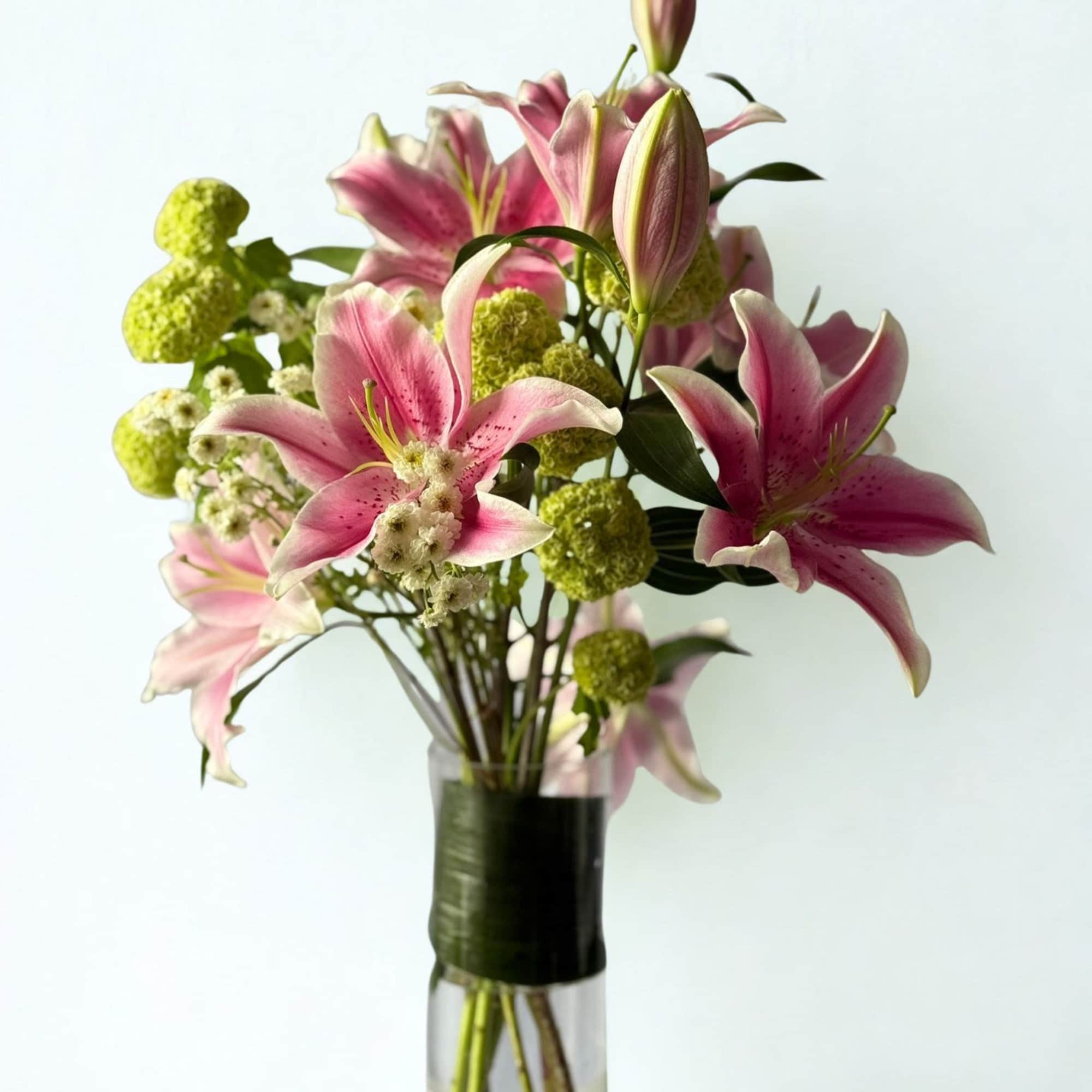 An elegant vase arrangement featuring fragrant pink oriental lilies paired with playful