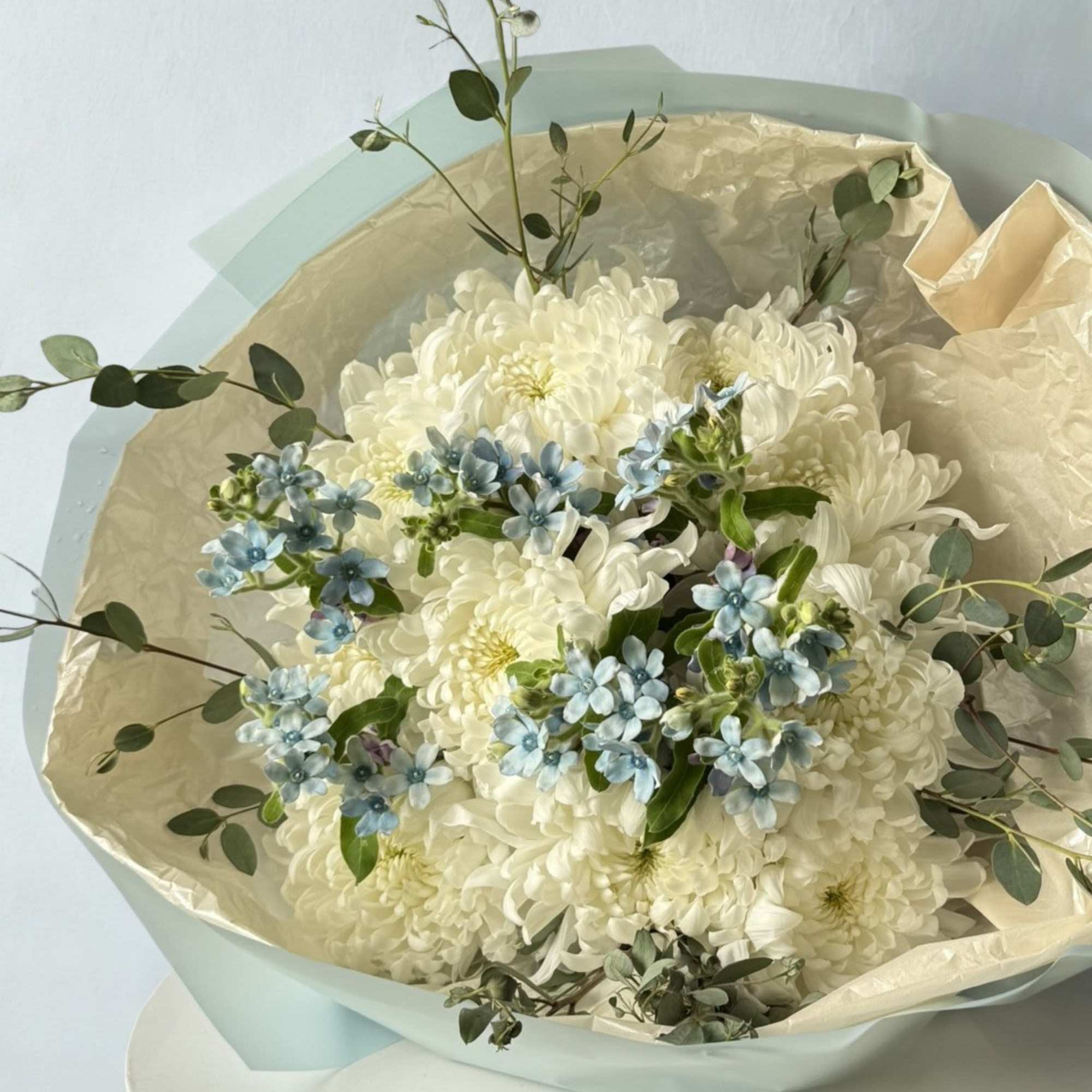 A soft and dreamy bouquet featuring lush white disbud chrysanthemums accented with
